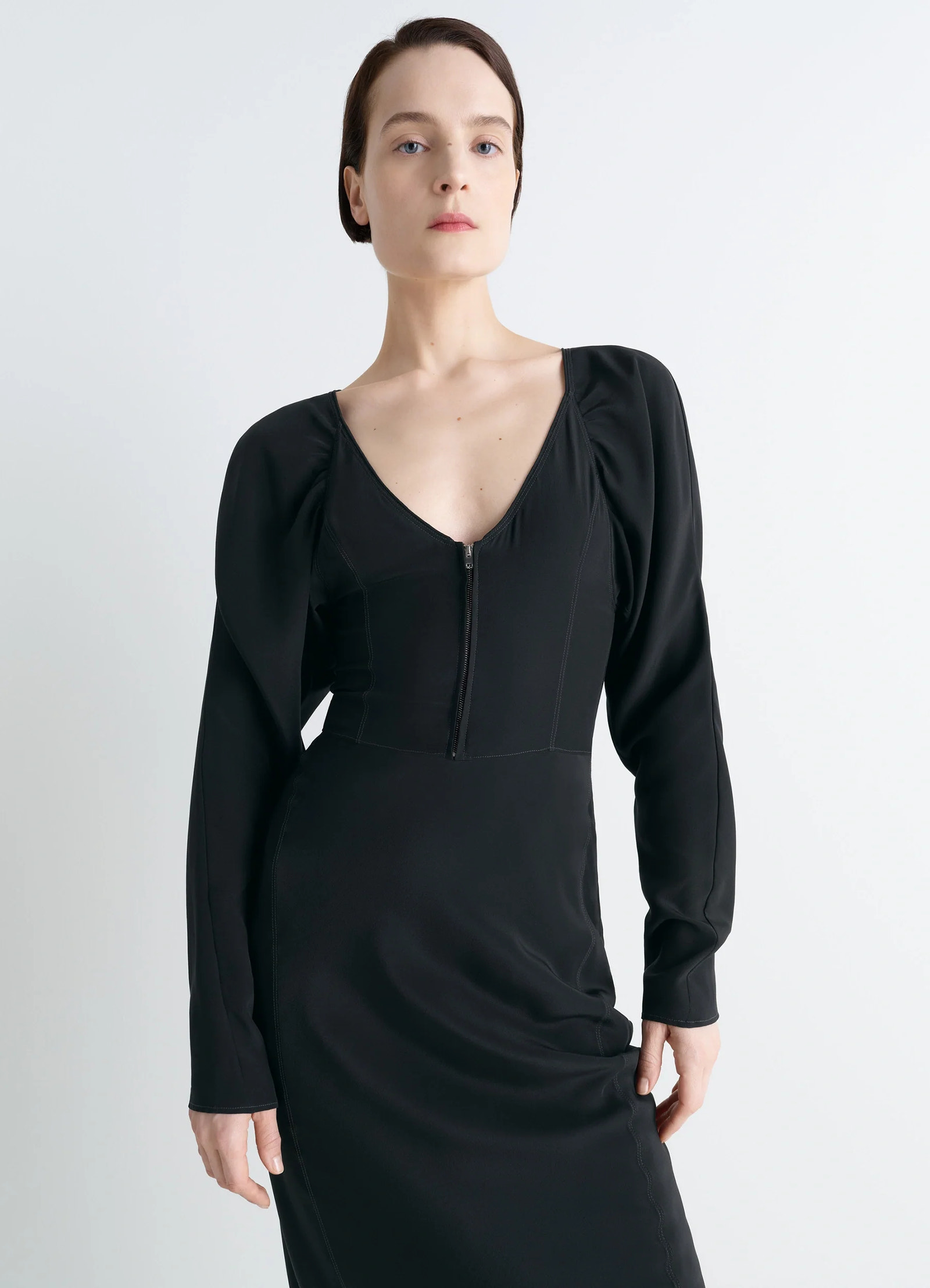 Bias cut dress in black silk crepe de chine, model shot, three-quarter view deep v-neck zipper front