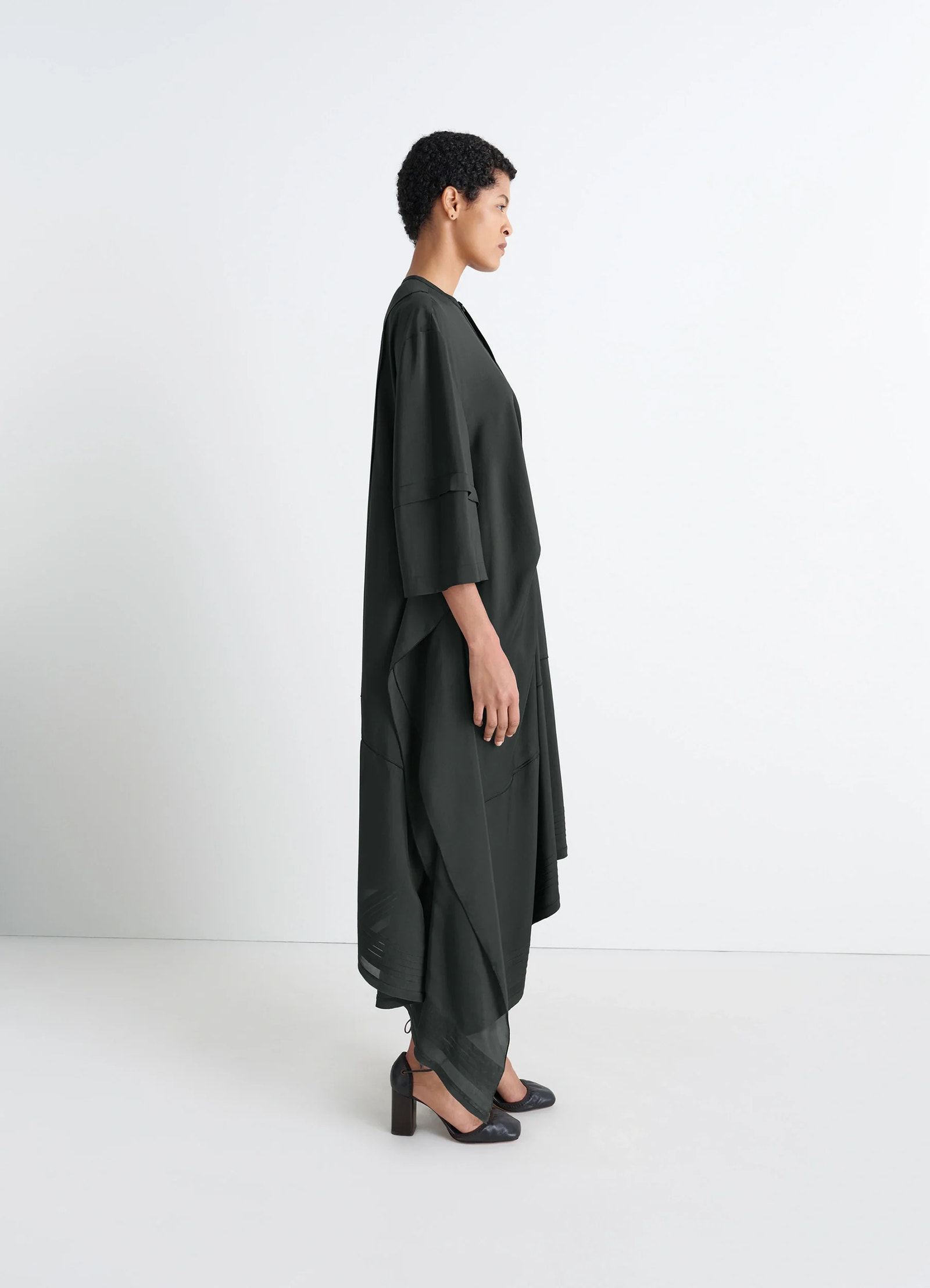 Blouse dress with pleats in black crêpe de chine, model shot, side upper view draped elbow-length sleeves