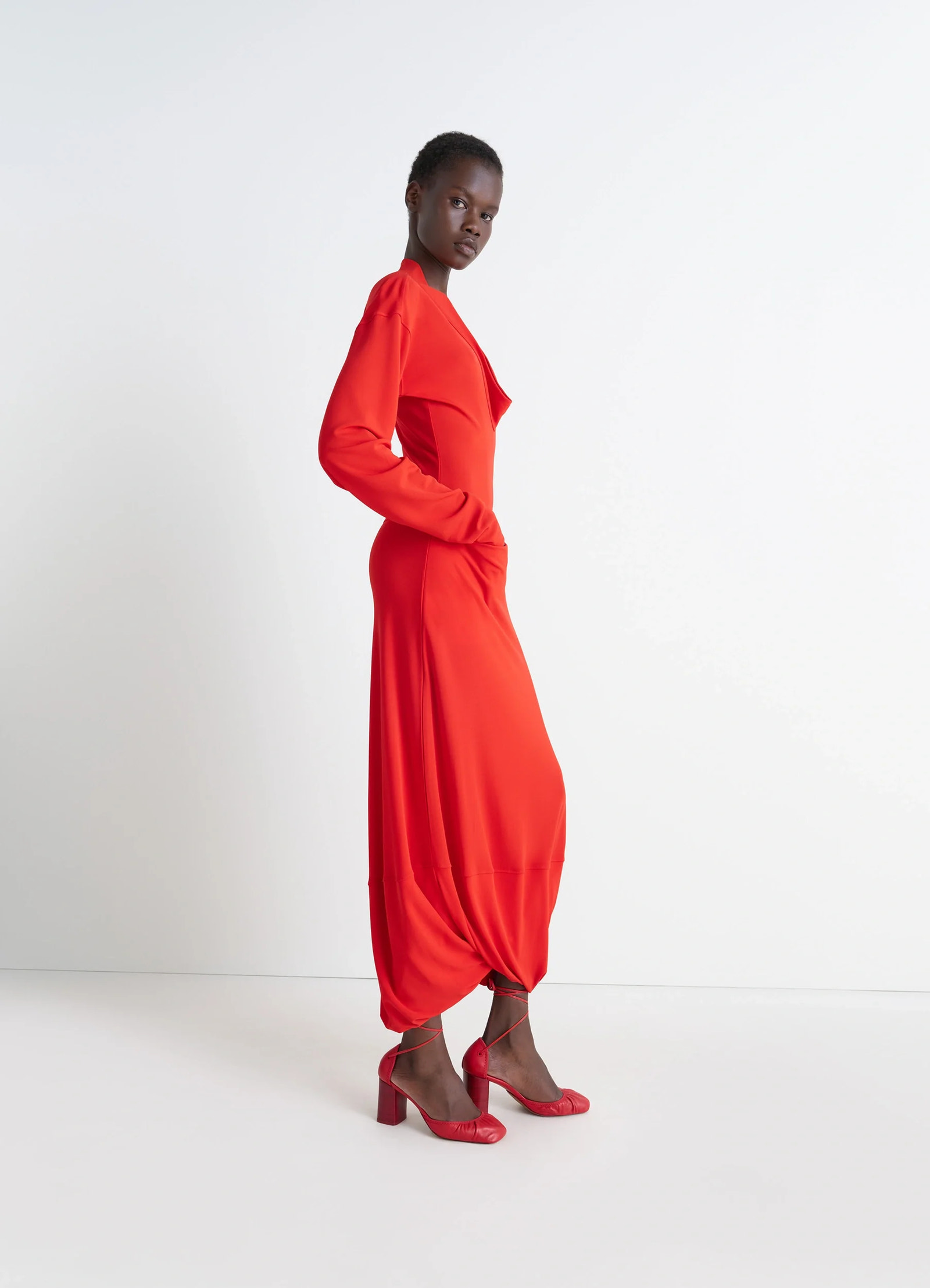Lemaire v-neck dress in red viscose crepe jersey, model shot, side view tulip hem drape