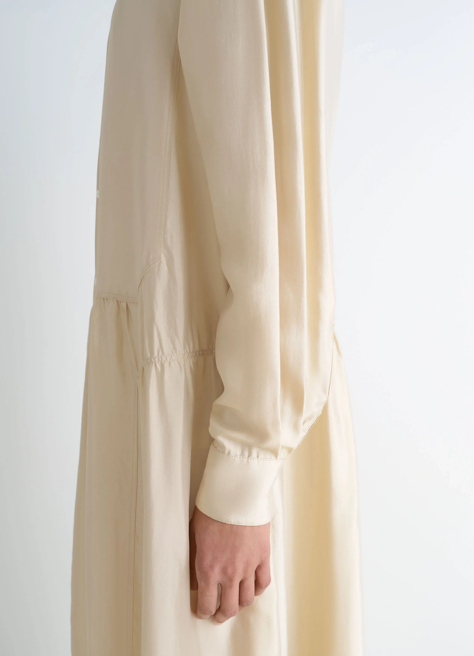 Lemaire buttoned dress in soft shiny silk, model shot, sleeve detail view cuffed sleeves, loose fit