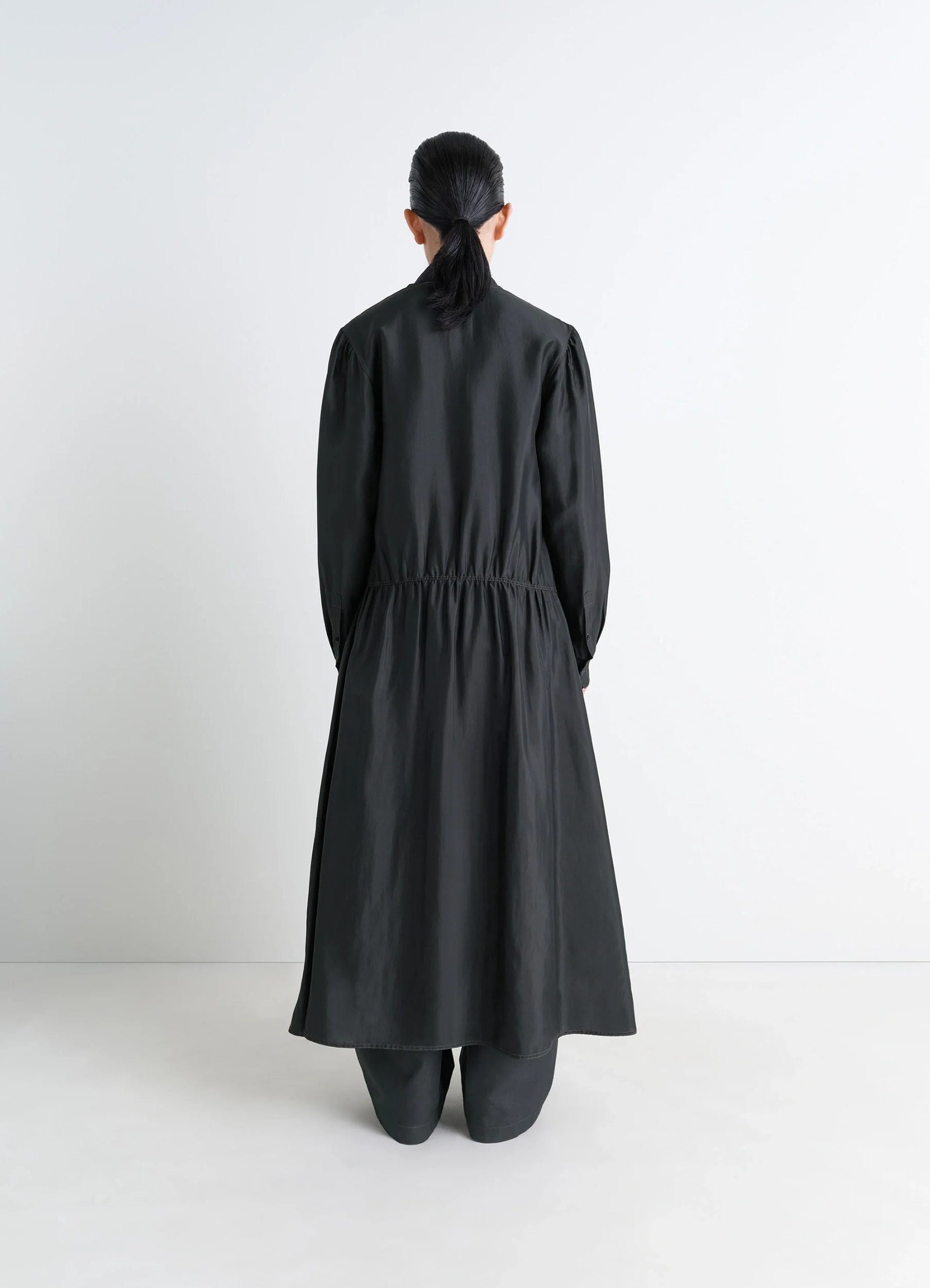 Lemaire buttoned dress in silk soft shiny black, model shot, back view elastic waist detail
