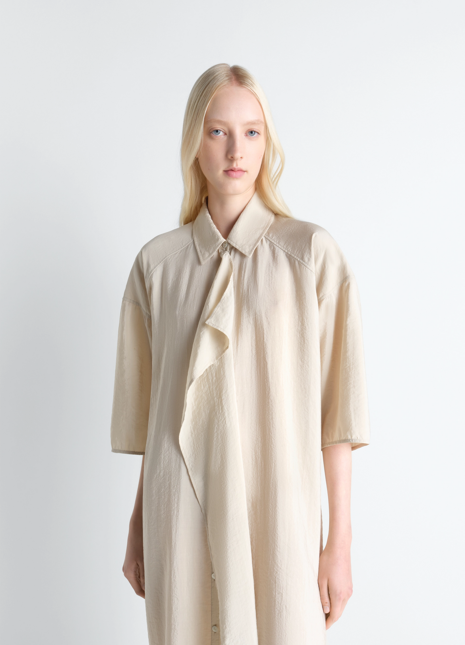 Asymmetrical shirt dress in dry silk, model shot, three-quarter view asymmetrical front drape