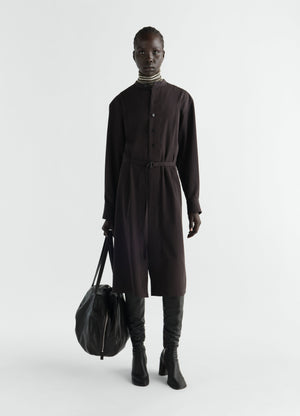 Belted black wool gabardine dress with long sleeves and mandarin collar worn by model lemaire