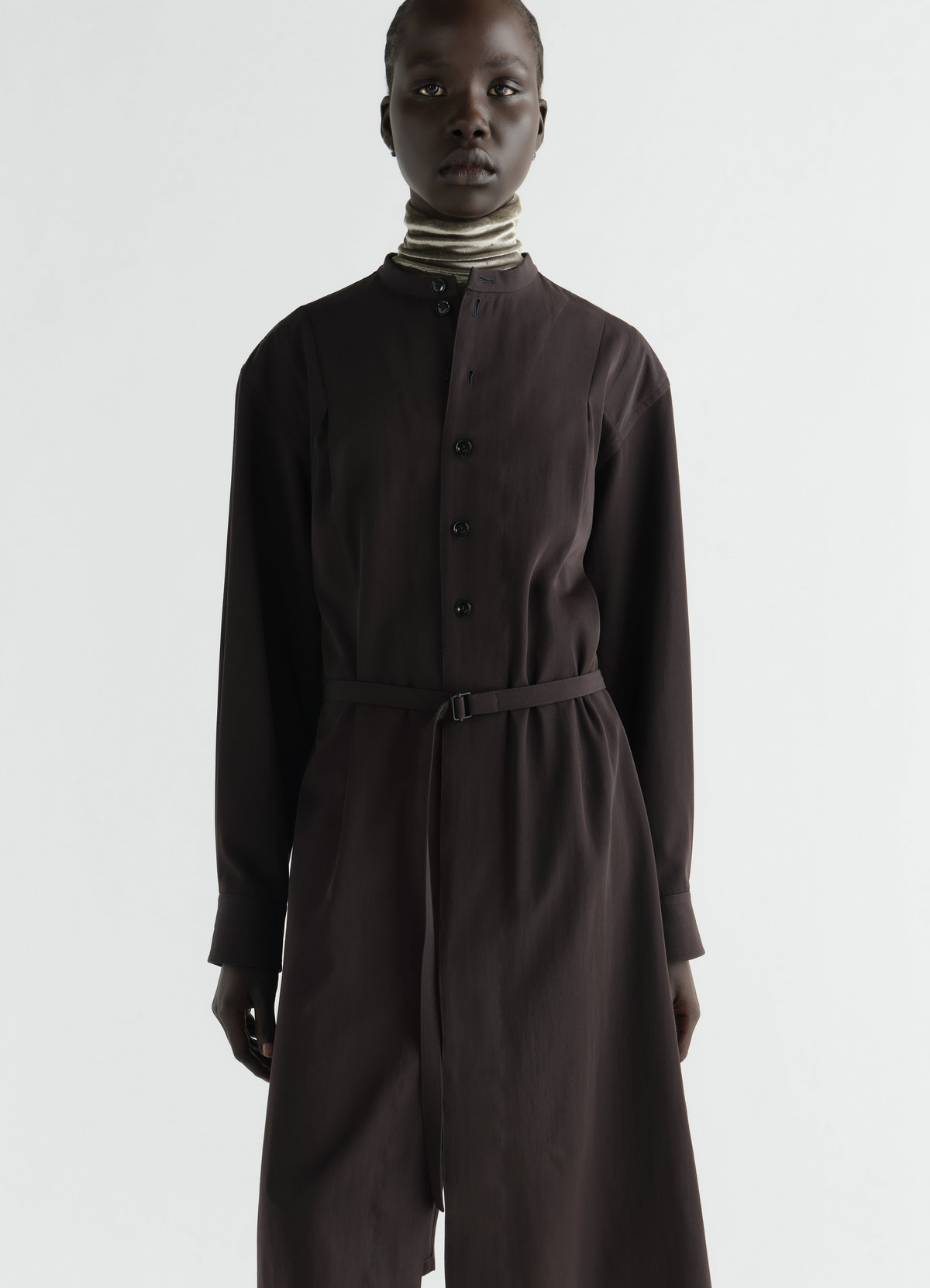 Belted dark brown wool gabardine dress with button front worn by model in lemaire front view