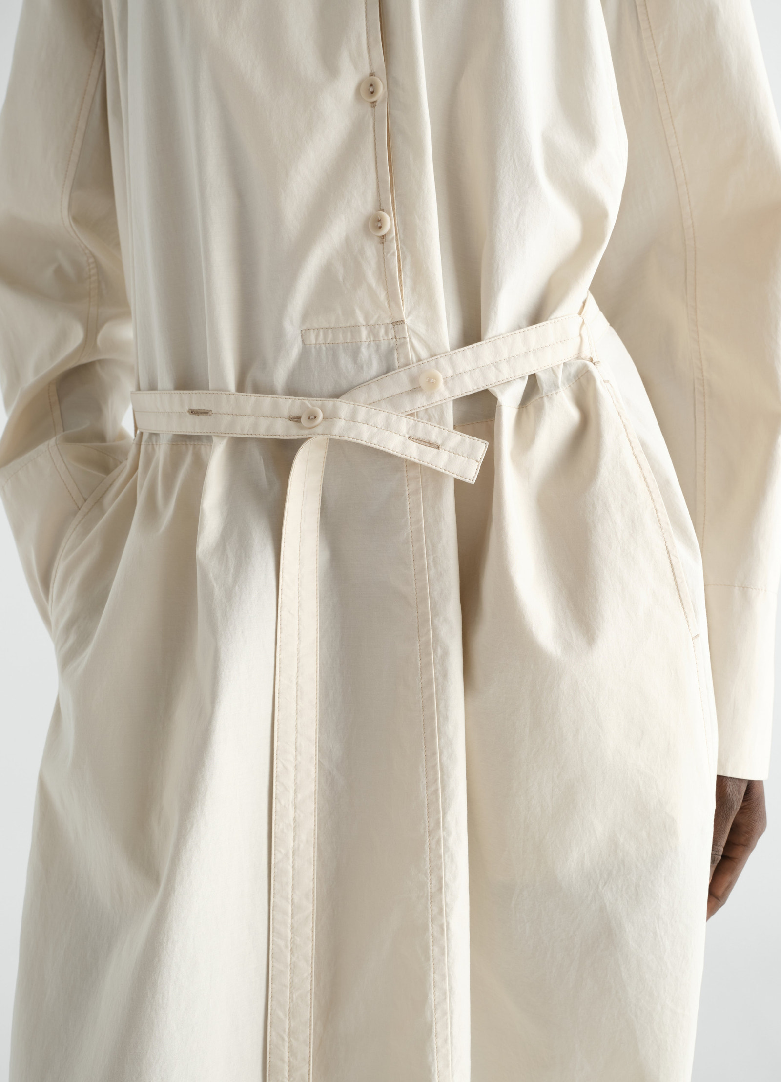 Sailor dress lemaire in washed beige cotton-silk blend with belt detail, close-up on waist worn by a model