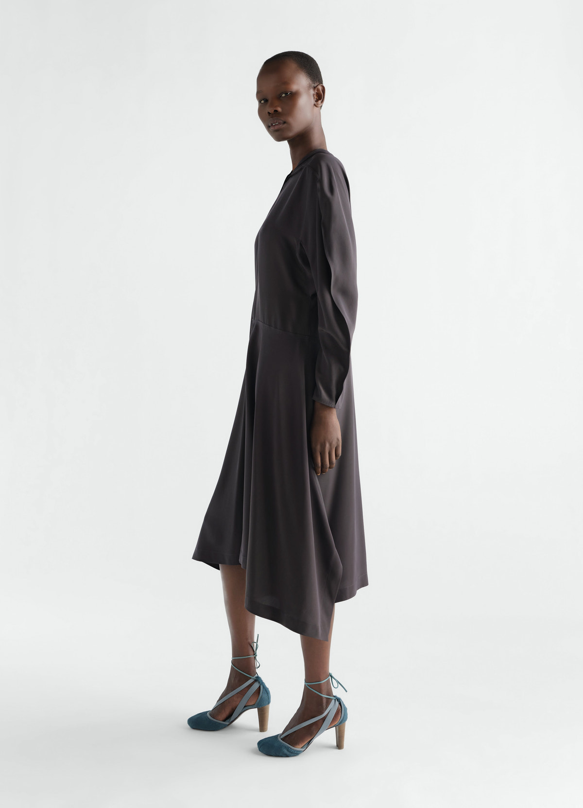 Midi dress in dark grey silk viscose cloth lemaire worn by model side view with long sleeves and flared skirt