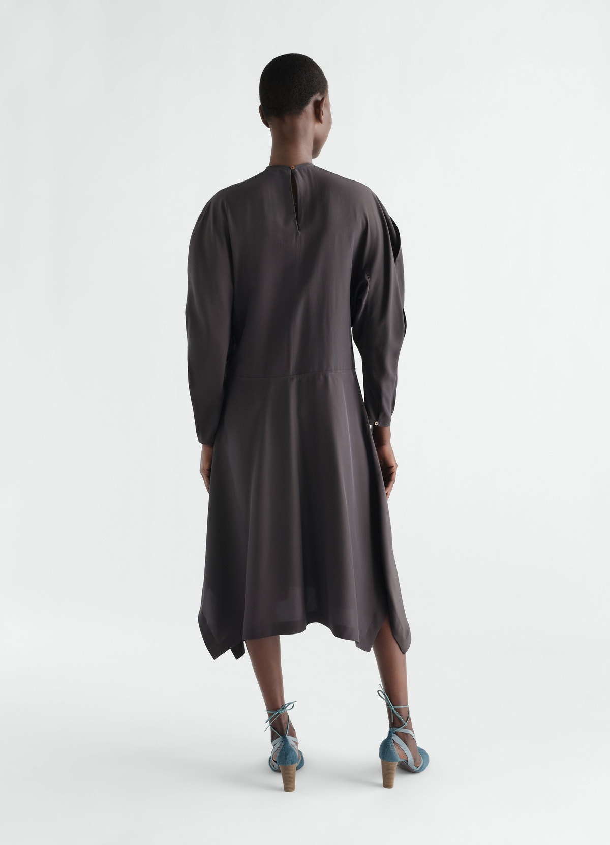 Midi dress in dark grey silk-viscose cloth lemaire worn by a model back view with long sleeves and button details