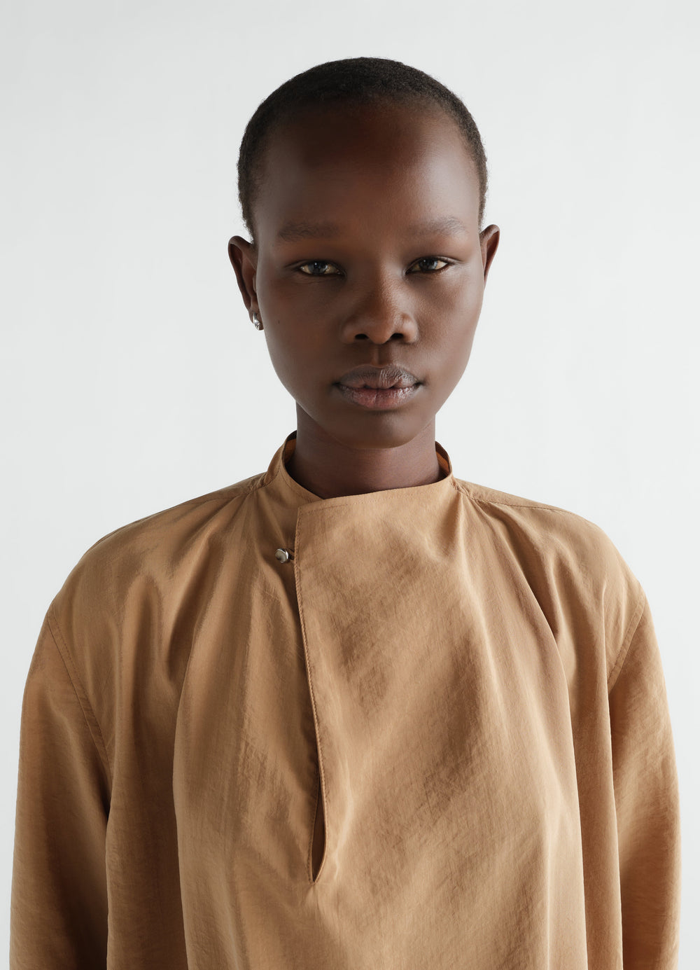 Soft-collar beige dry silk dress LEMAIRE worn by a model front close-up with asymmetric snap closure
