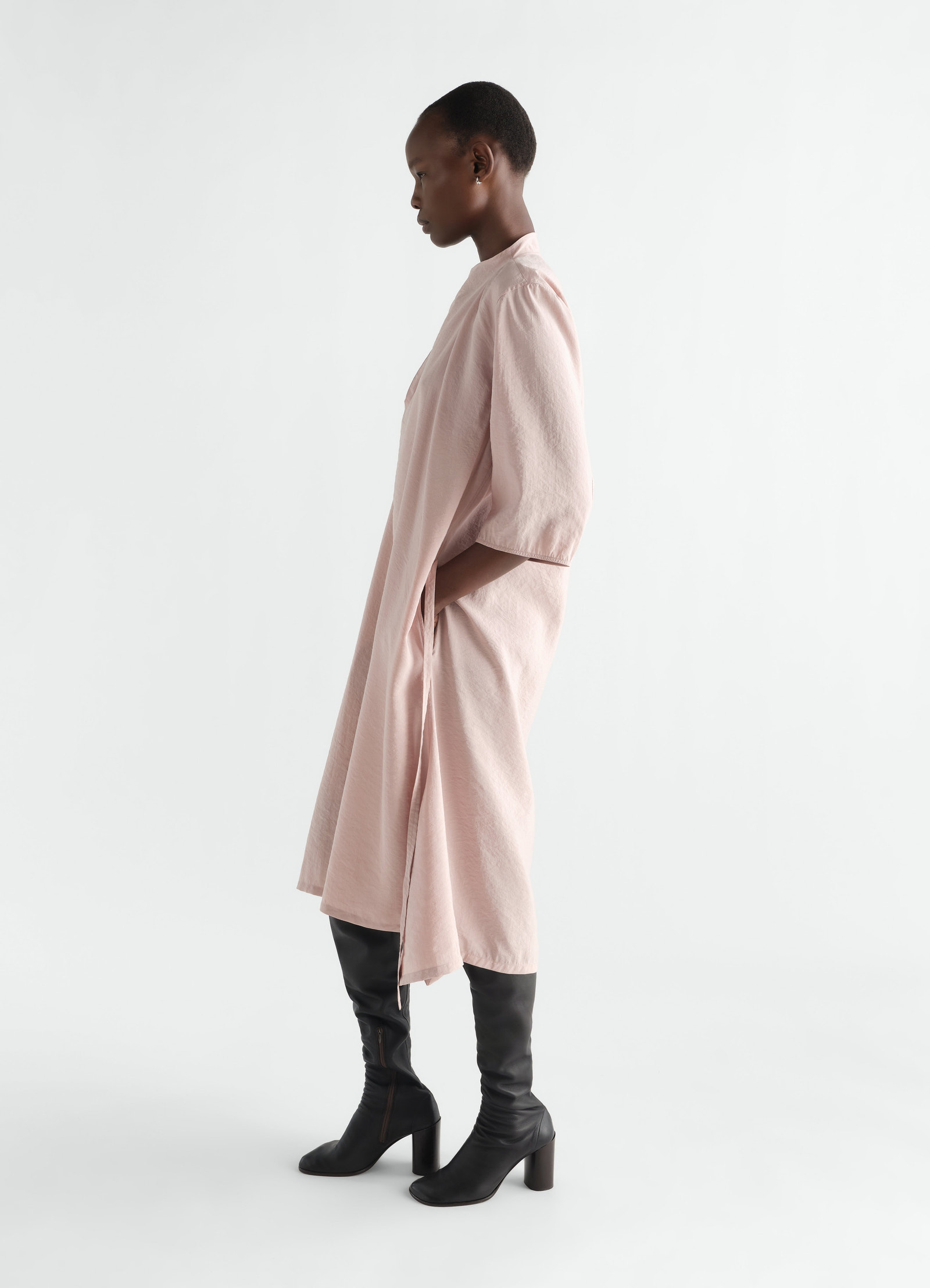 Soft-collar pink dry silk dress lemaire worn by model side view with black leather boots