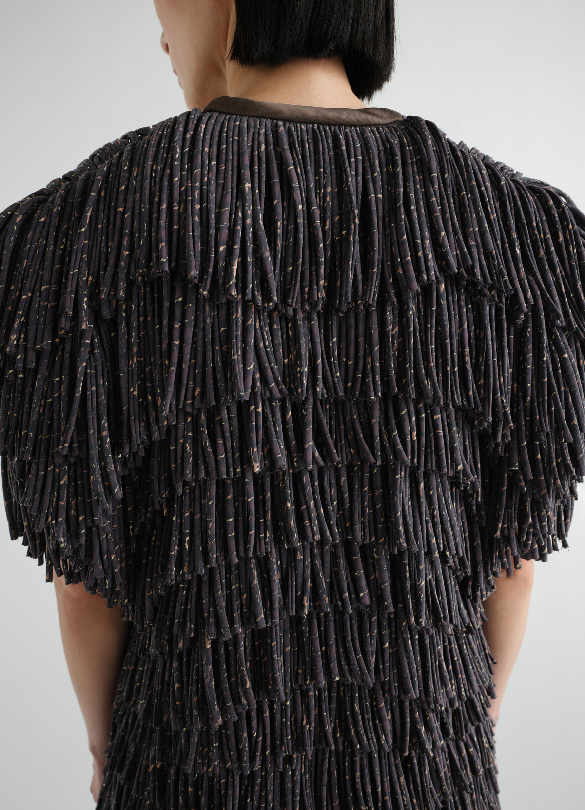 Fringed snake print dry silk dress by lemaire detailed back view worn by a model with layered pleats