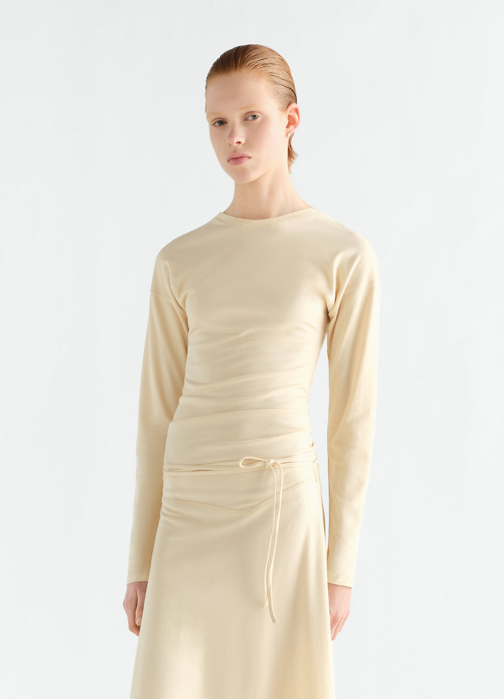 Fluid long-sleeve beige jersey crepe dress with waist tie worn by model LEMAIRE front view
