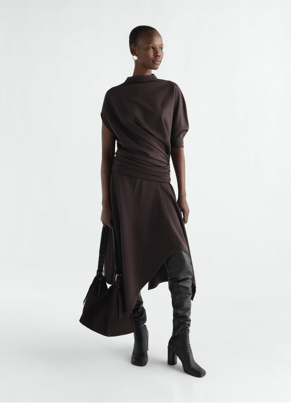 Twisted wool-blend jersey dress in dark brown by LEMAIRE worn by model with black boots and bag
