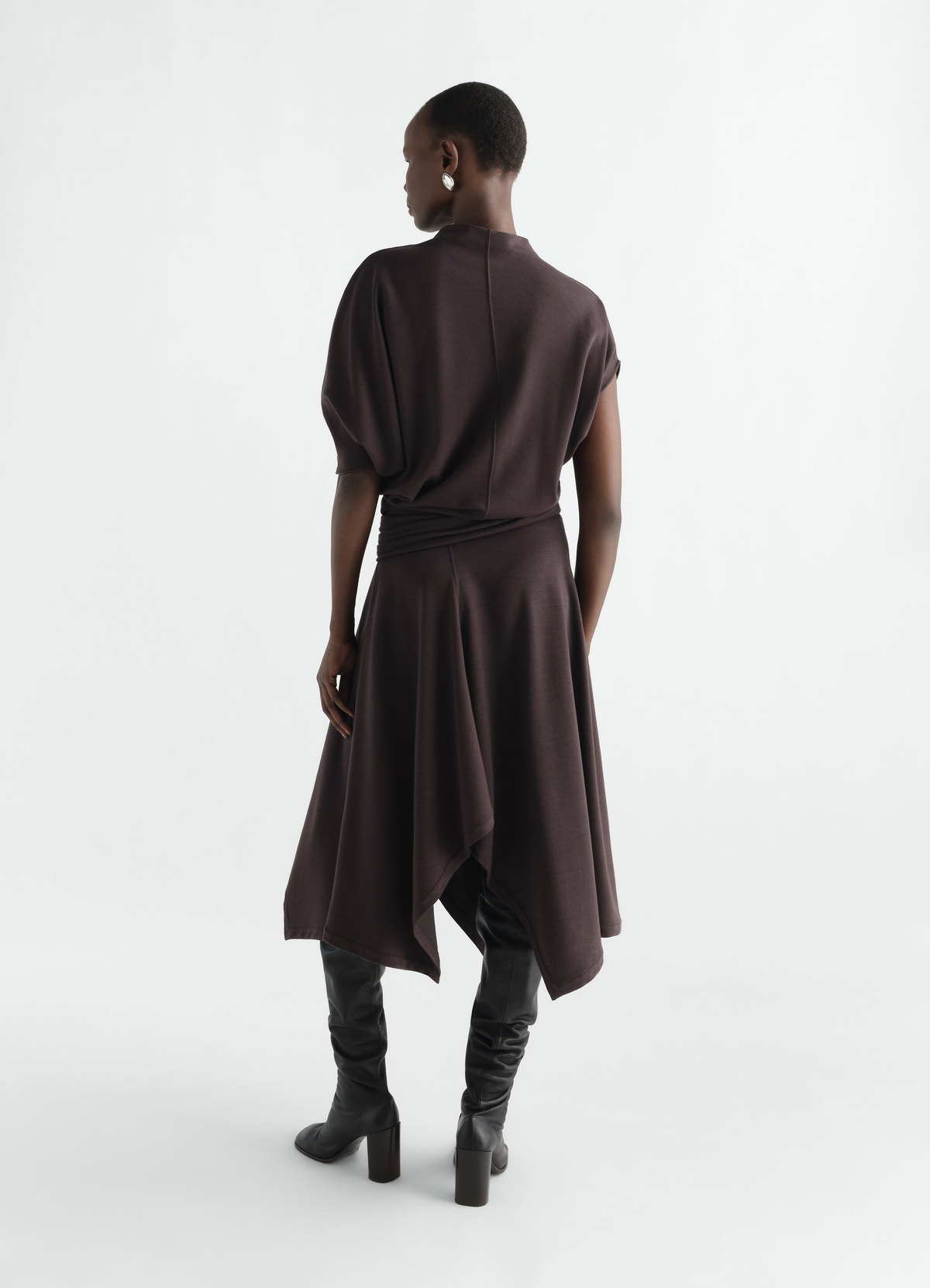 Twisted wool-blend jersey dress in dark brown by lemaire worn by a model back view with black boots