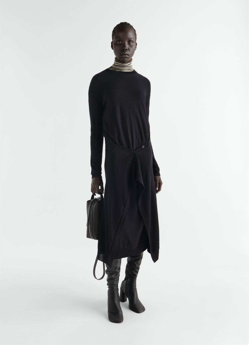 Buttoned black merino wool blend dress by LEMAIRE worn by a model with leather boots and striped turtleneck