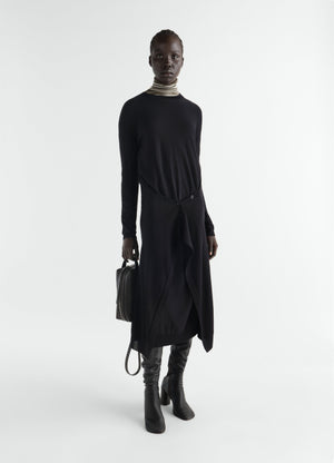 Buttoned black merino wool blend dress by lemaire worn by a model with leather boots and striped turtleneck
