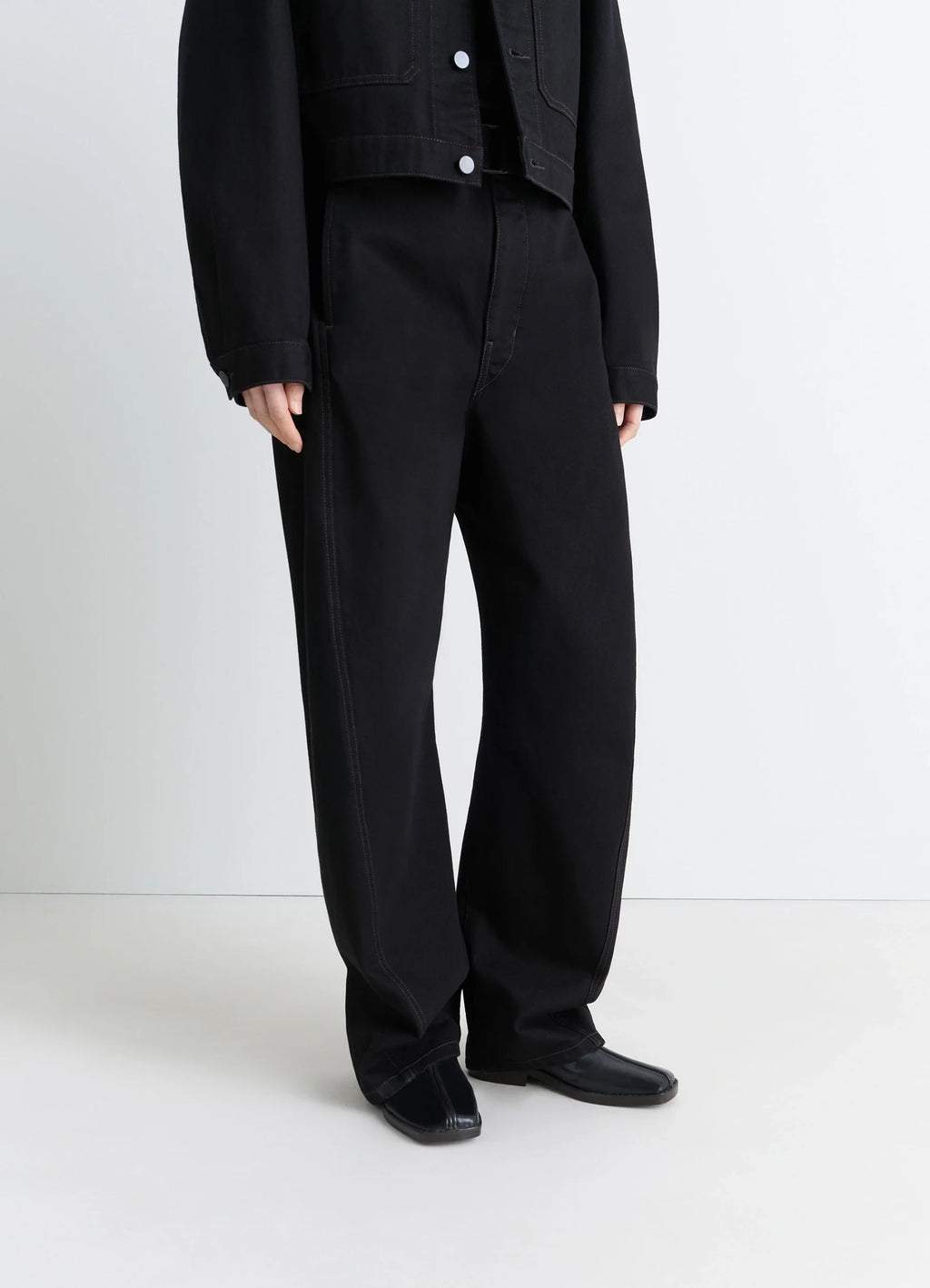 Lemaire Piped Slippers in Black Nappa Leather, model shot, worn frontal view sleek piped design visible