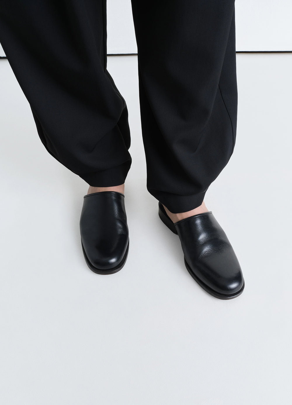 Lemaire Square Mule in Black Vegetable-Tanned Buffalo Leat, model shot, top-down view loose fit pants