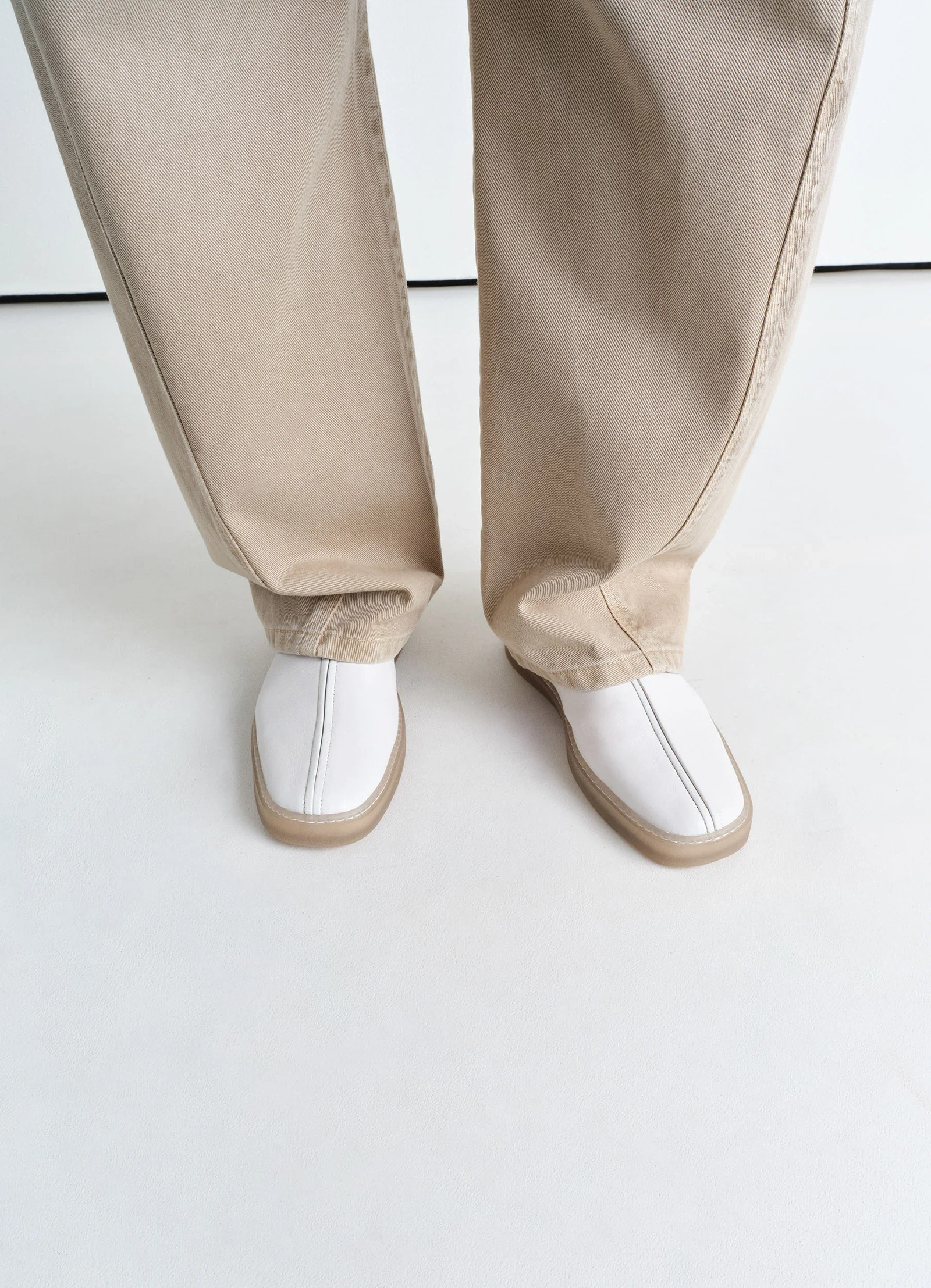 Lemaire linoleum piped sneakers in smooth soft cow leather, model shot, top down view contrast piping