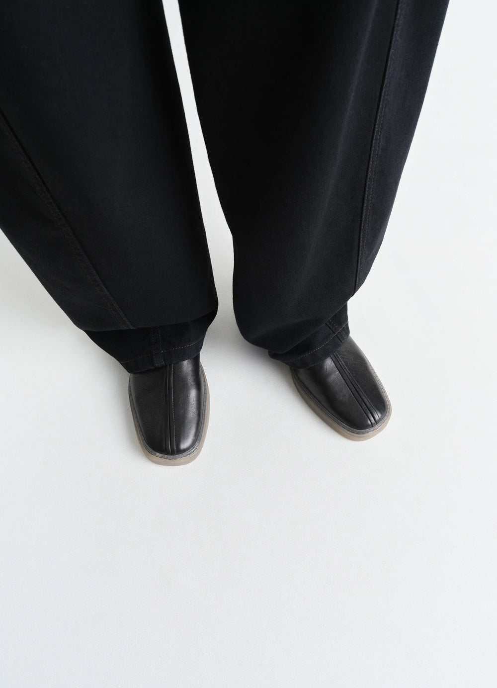 Linoleum Piped Sneakers in Black Cow Leather, model shot, top down view minimalist design