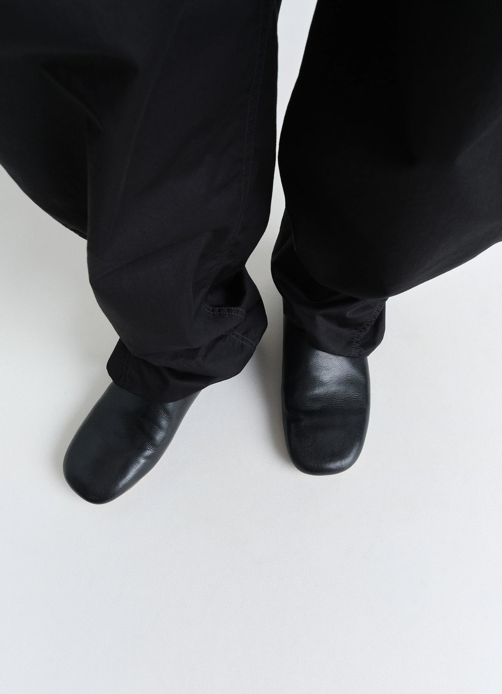 LEMAIRE Slippers in Black Shiny Buffalo Leather, model shot, top-down view square toe design