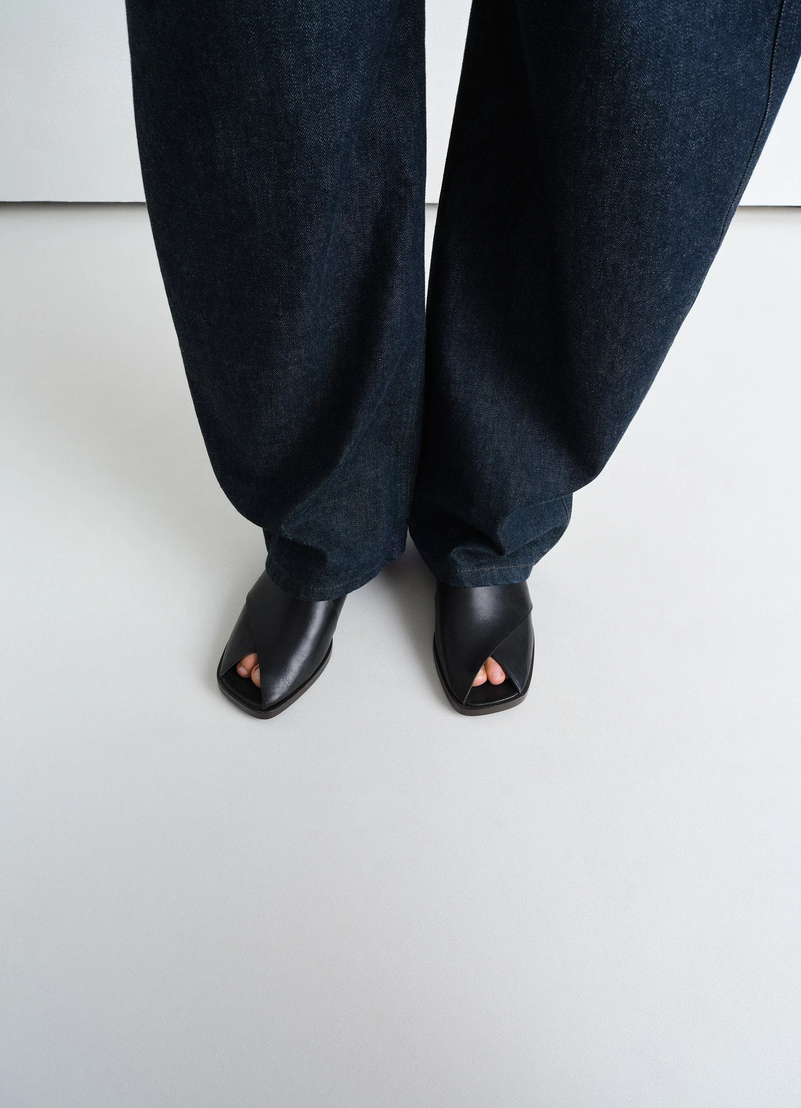 Lemaire cross flat sandals in black vegetable nappa leather, model shot, top view crossed strap