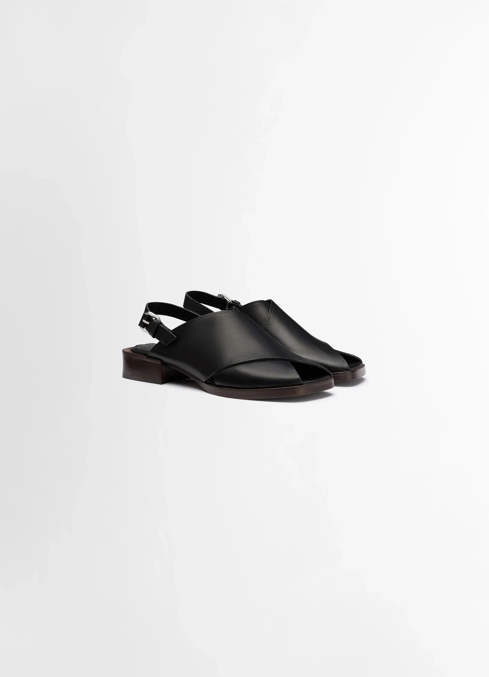 Lemaire cross flat sandals in black vegetable nappa leather, product shot, three-quarter view adjustable ankle strap