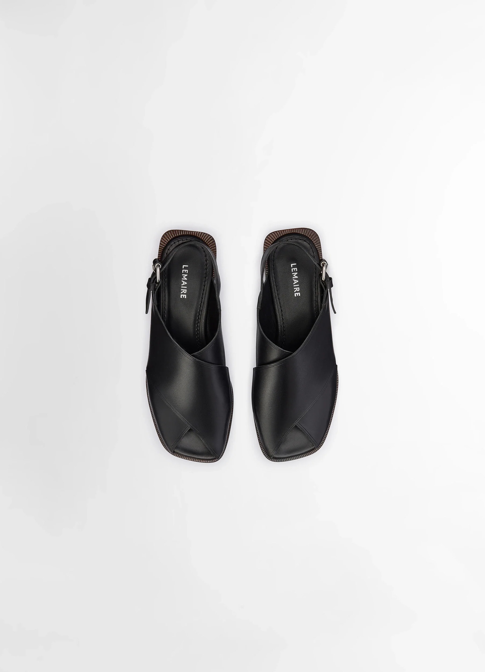 Lemaire cross flat sandals in black vegetable nappa leather, product shot, overhead top-down view double strap with stitched