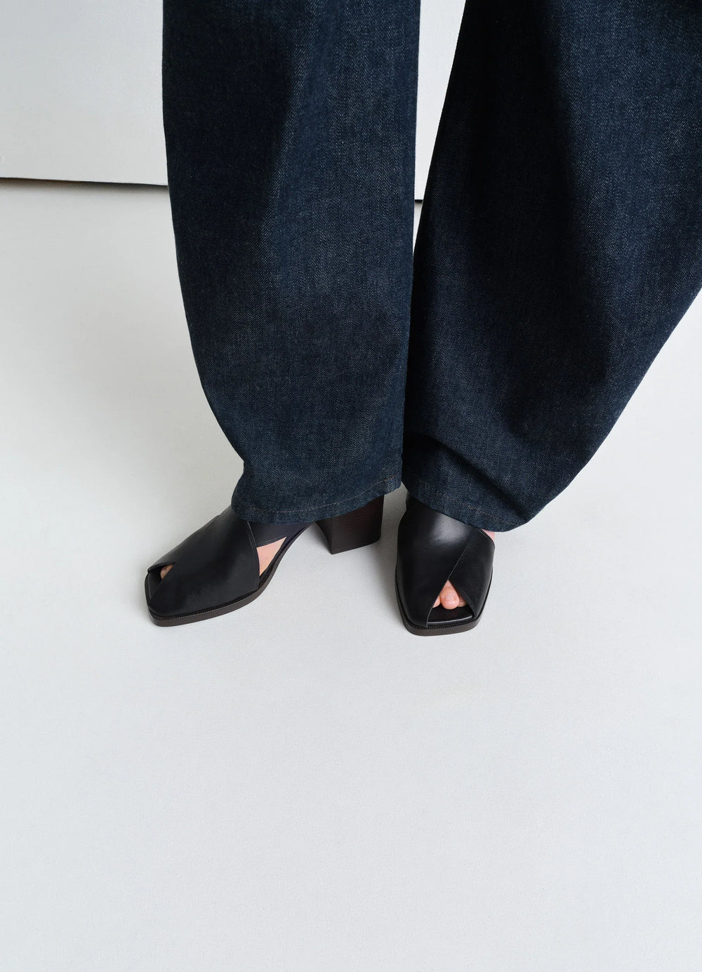 LEMAIRE Cross Sandals 80 in Black vegetable nappa leather, model shot, top-down view thick block heel