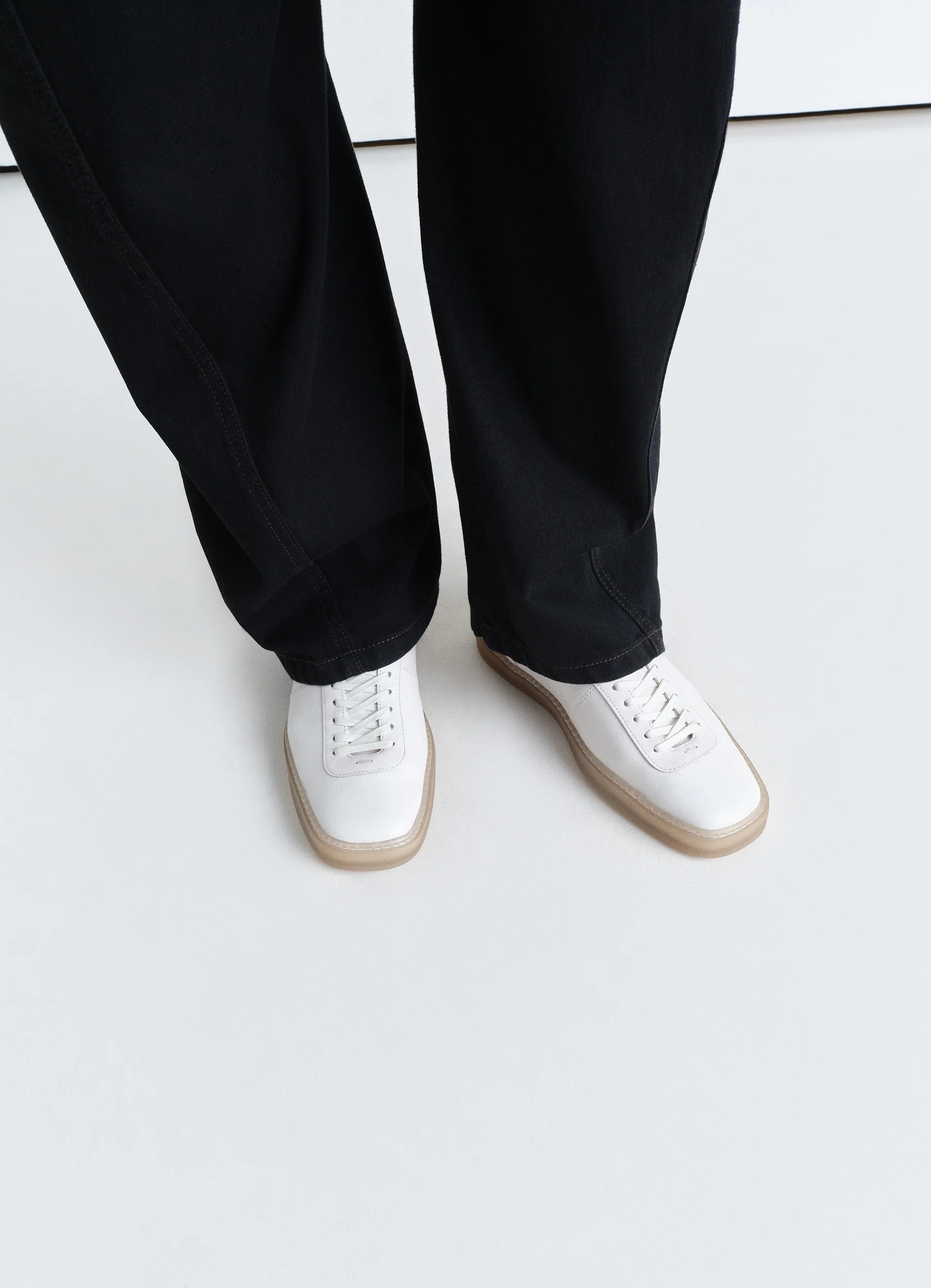 Lemaire linoleum laced up sneakers in smooth soft cow leather, model shot, top view worn with wide leg pants