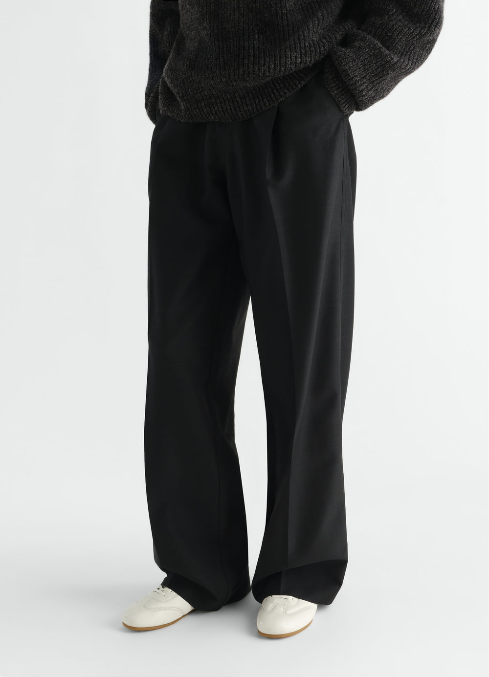 Soft black leather Soft Runner shoes by LEMAIRE worn by model with black trousers front view