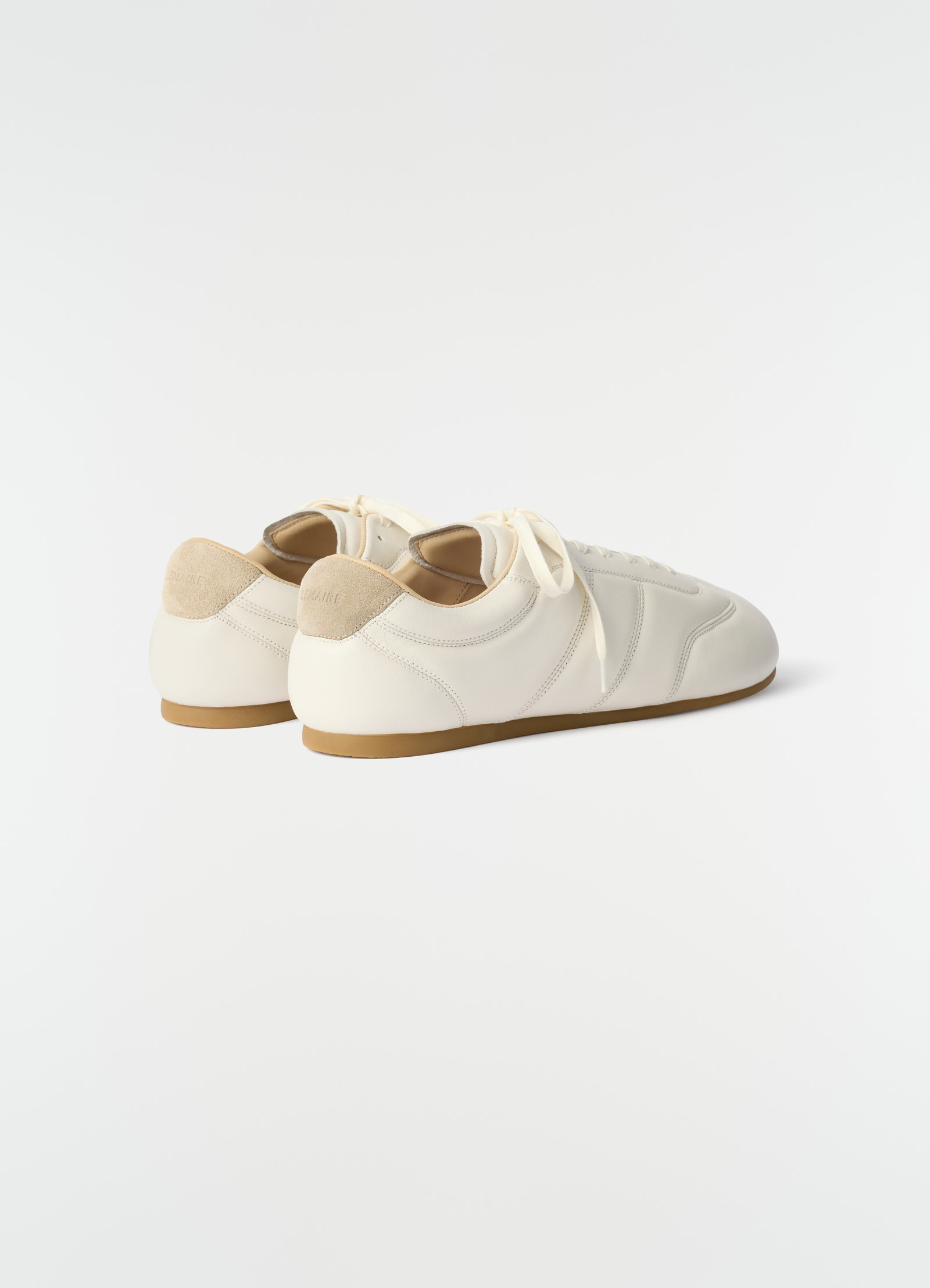 Soft runner leather sneakers in off-white with beige suede heel by lemaire side view on plain background