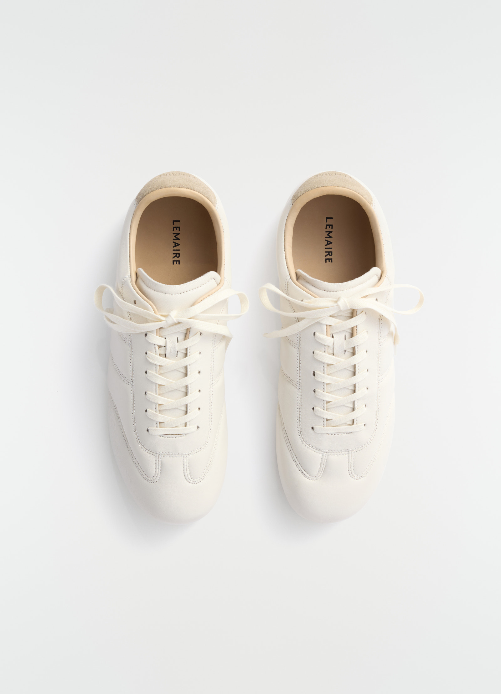 Soft runner sneakers in off-white leather by lemaire front view laid flat on white background