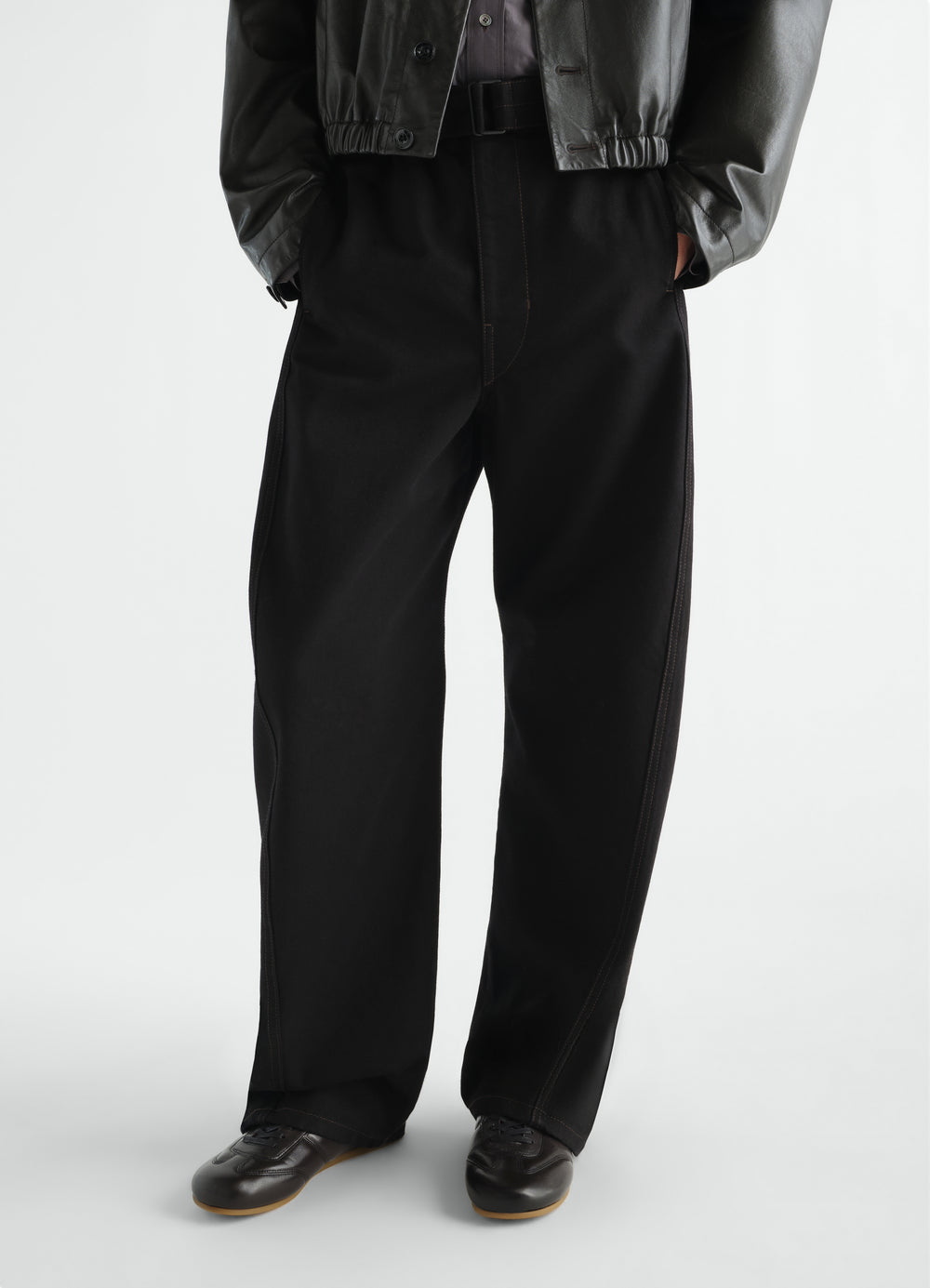 Soft black leather runner shoes with gum sole worn by a model styled look LEMAIRE