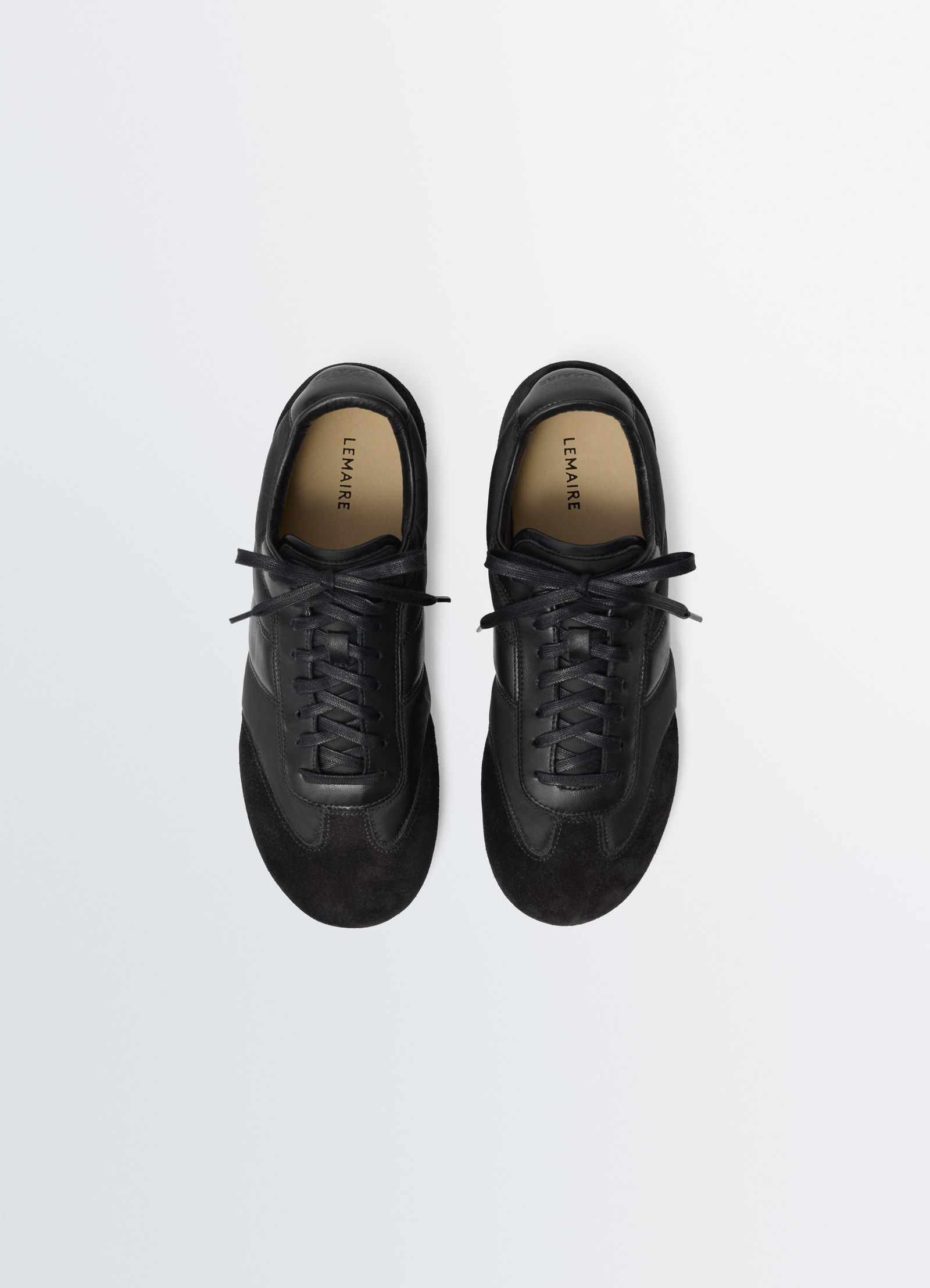 Soft runners in black suede leather, product shot, top view sleek lace-up design