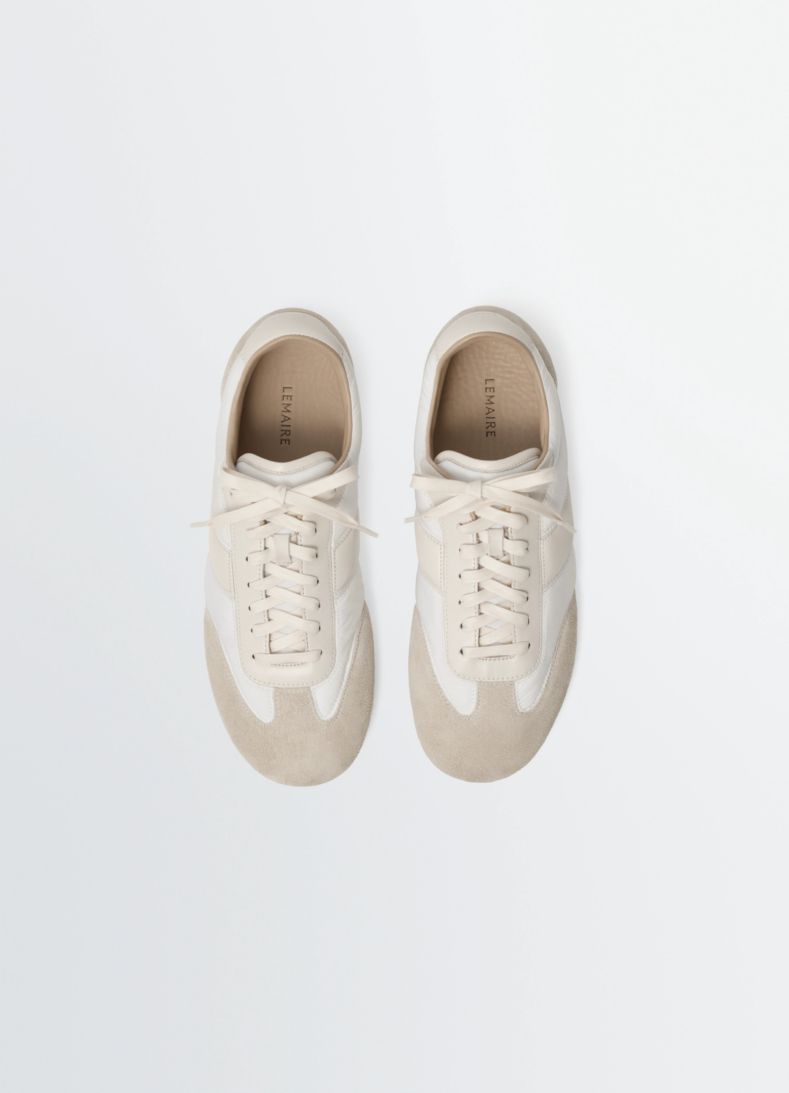 Soft runners in suede leather, product shot, aerial top-down shot minimalist lacing pattern