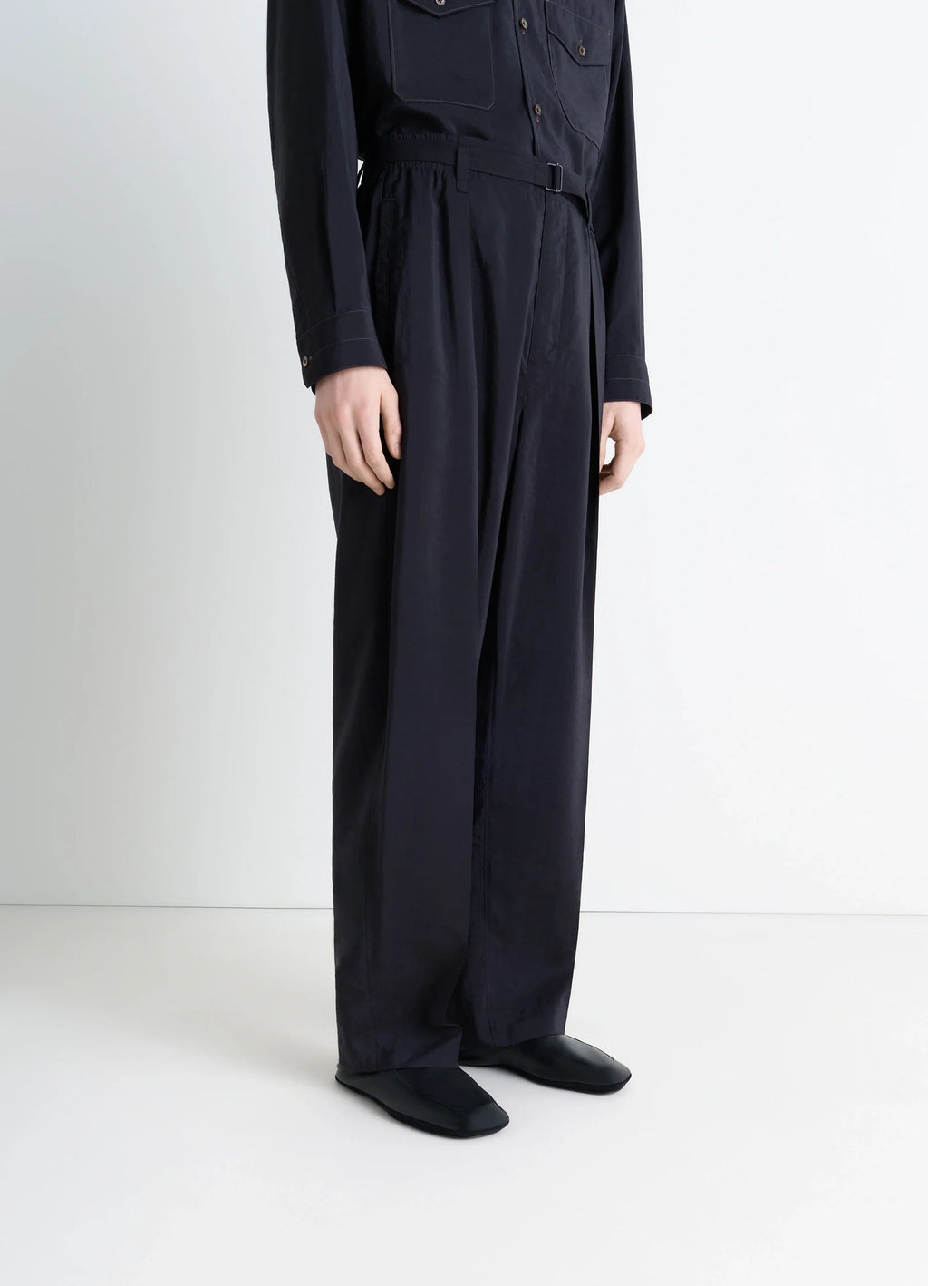 Indoor Slippers in Black Nappa Lamb Leather, model shot, lower body view sleek fitted design