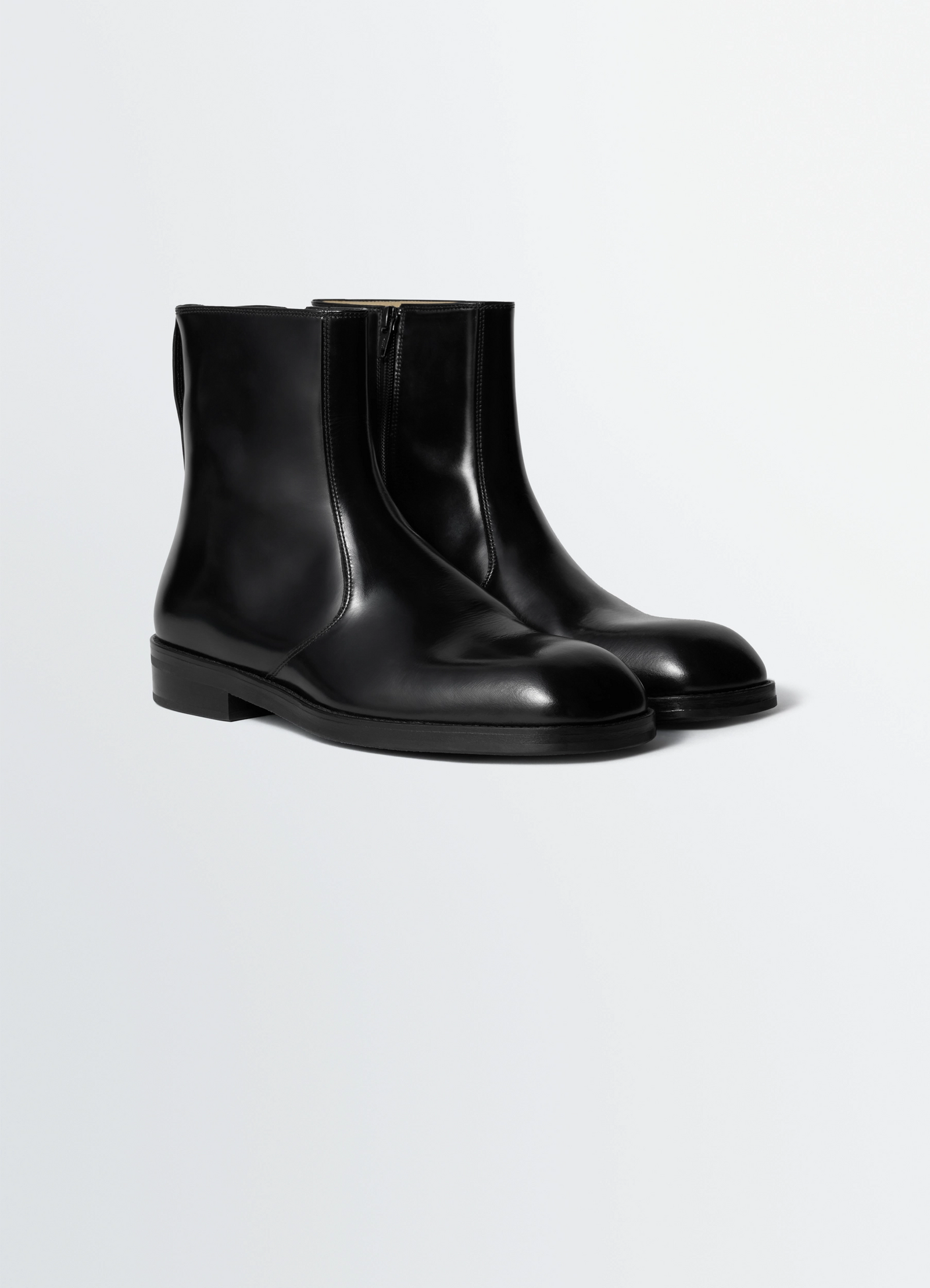 Zipped boots in leather in black calf leather, product shot, three-quarter view sleek toe design