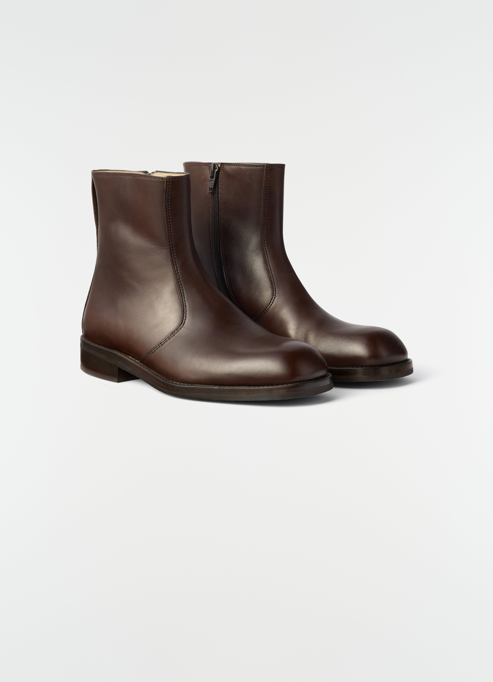 Zipped brown leather ankle boots in shiny finish by lemaire side view on white background