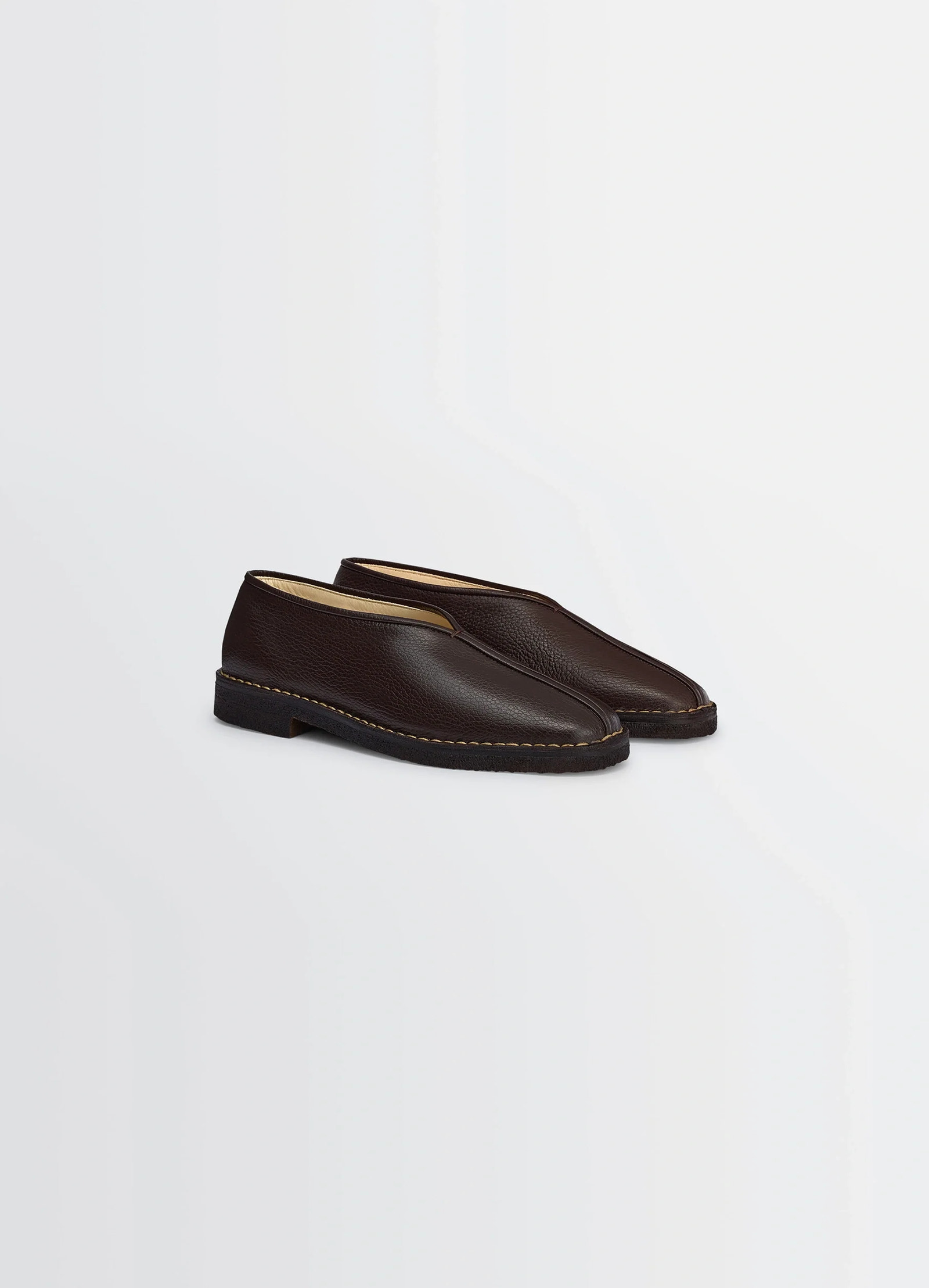 Lemaire piped crepe slippers in grained leather, product shot, three-quarter view minimalist piping