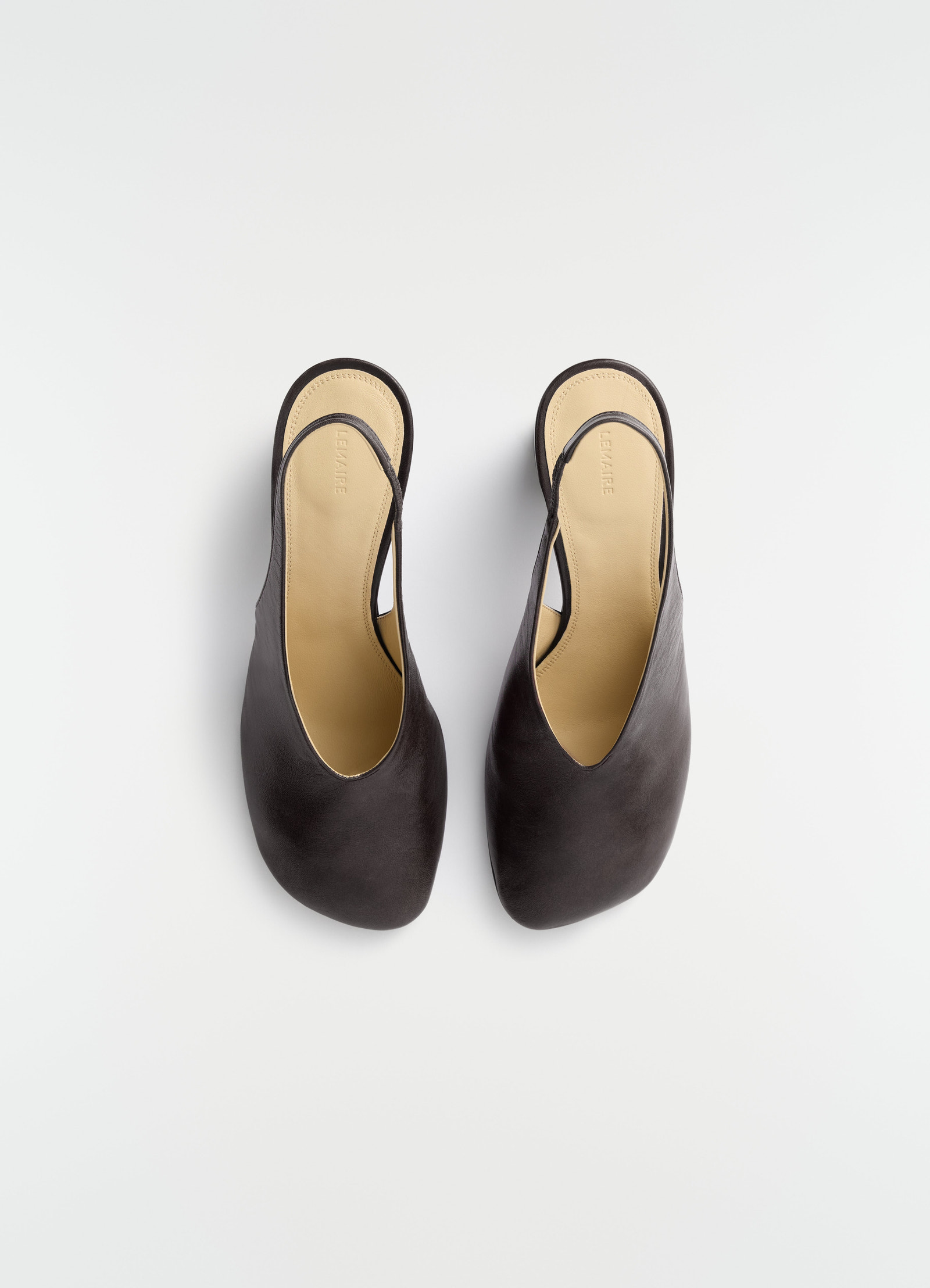 80mm black lambskin slingback pumps by lemaire with cushioned beige insole top view on plain background