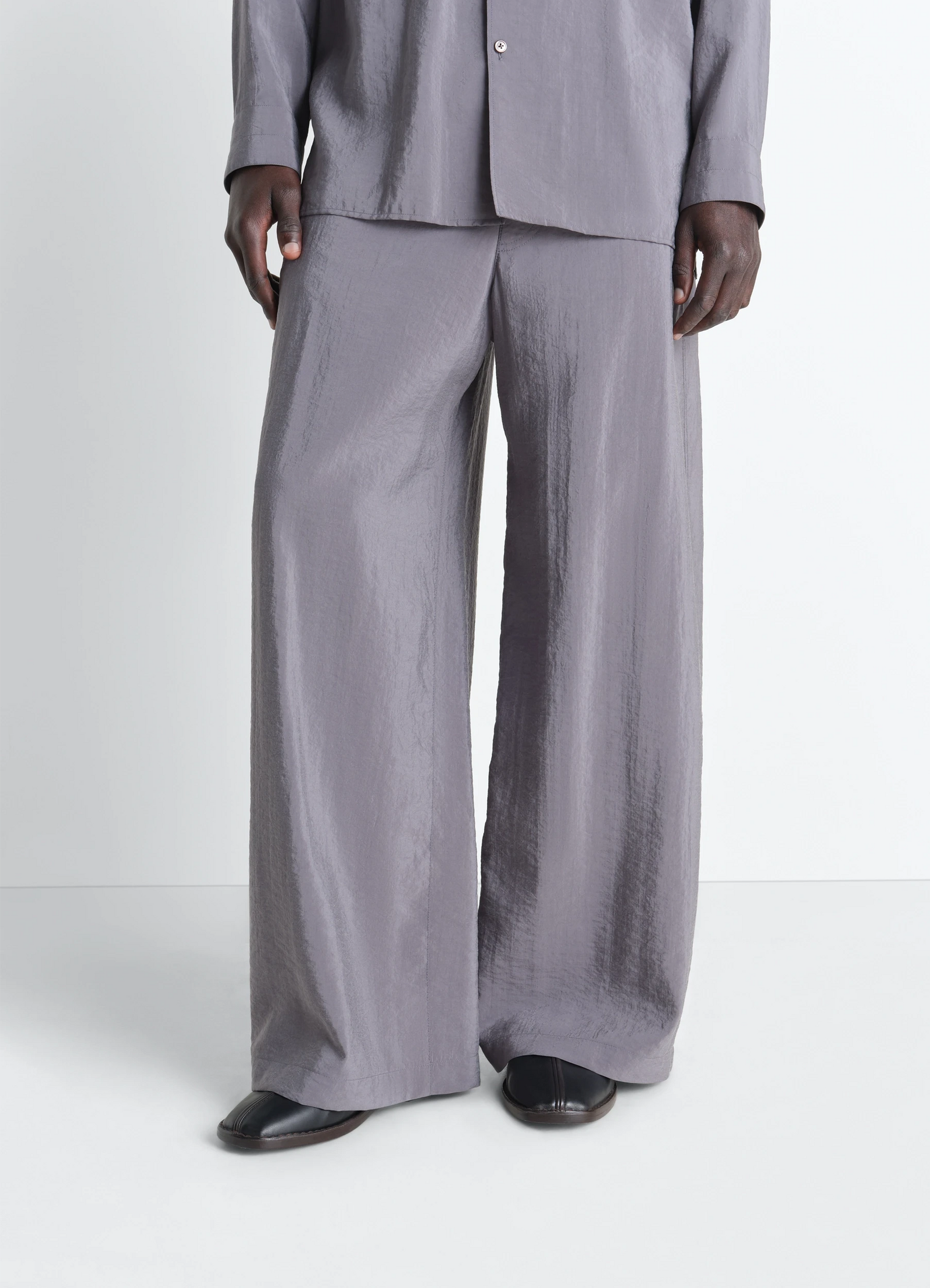 Lemaire flat piped slippers in black lwg gold-certified nappa leat, model shot, front detail shot textured wide leg shown