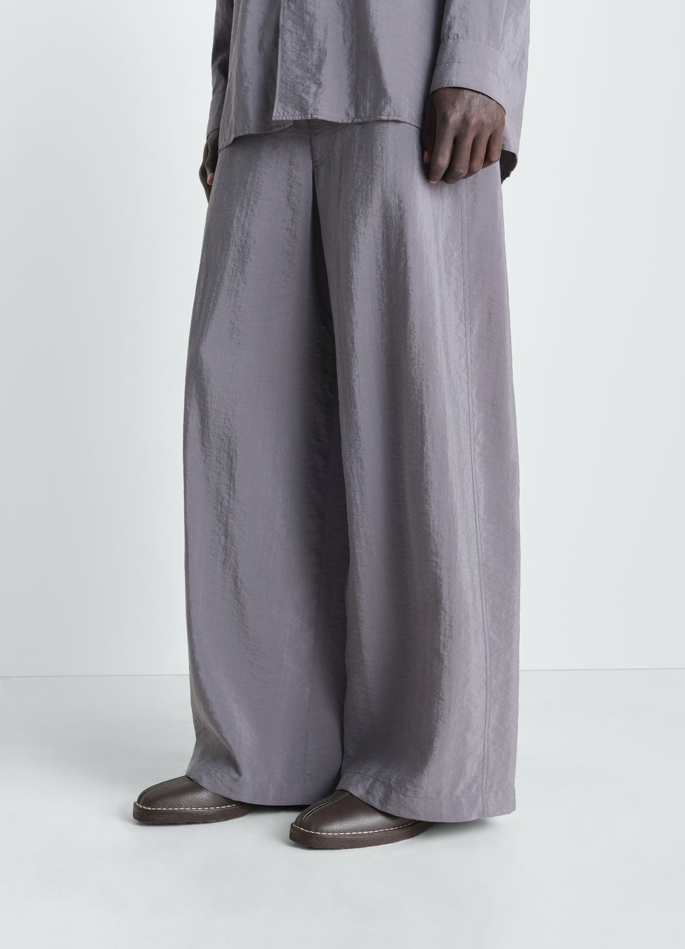 Piped leather slippers in dark brown worn by model front view LEMAIRE