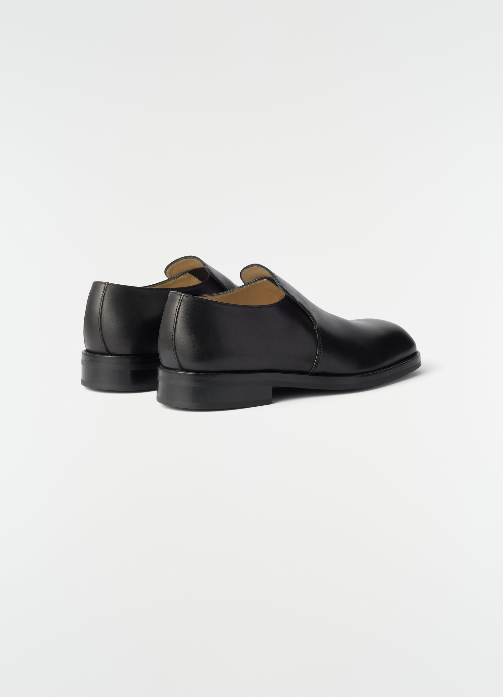 Formal black shiny leather loafers lemaire side view on plain white background