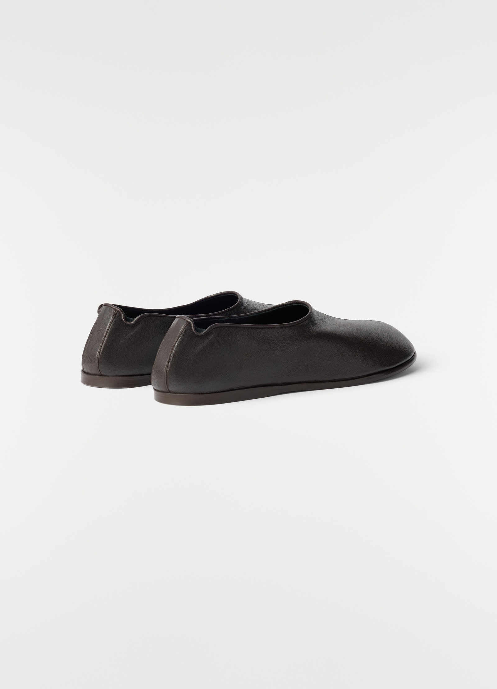 Sock slip-ons in dark brown goat leather by lemaire shown from back side on white background.