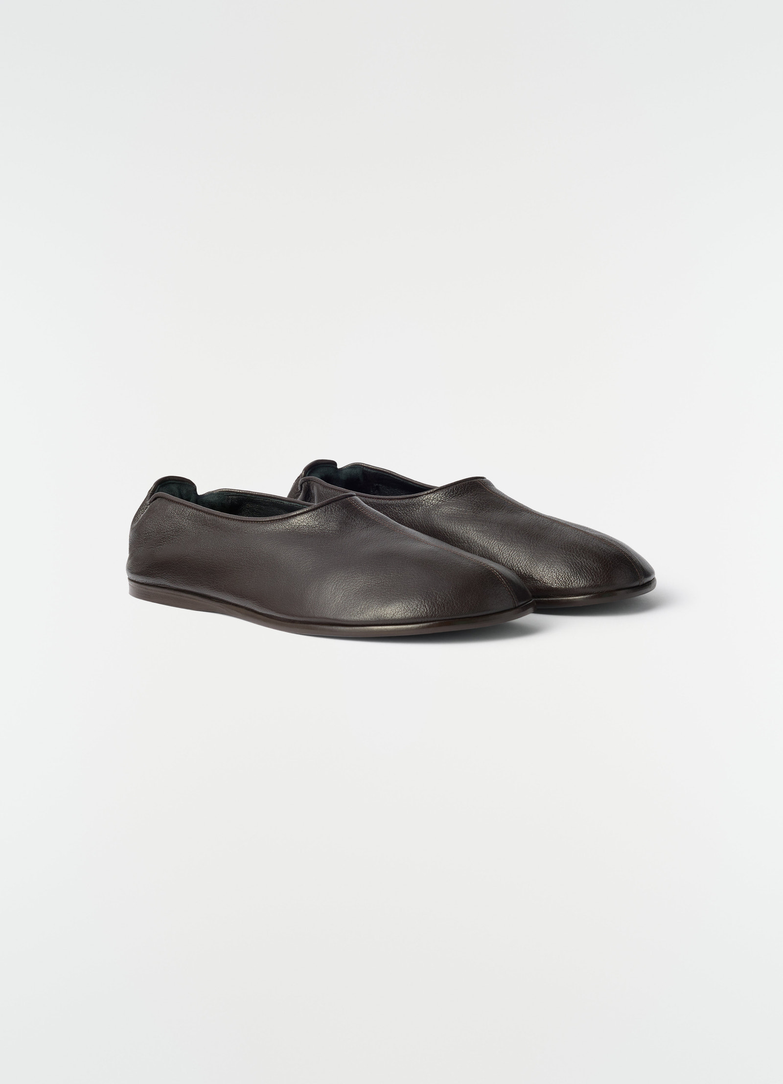 Sock slip-ons in dark brown goat leather by lemaire styled on plain white background side view