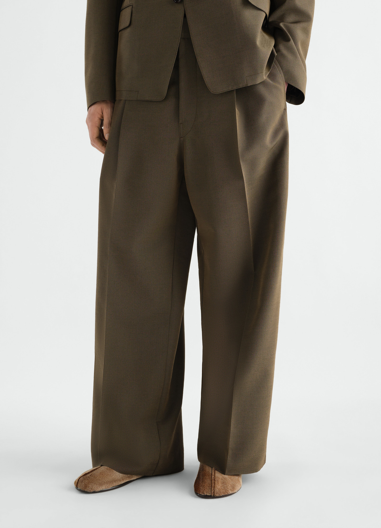 Sock slip-ons in natural pony-style leather lemaire worn by a model with brown wide trousers front view