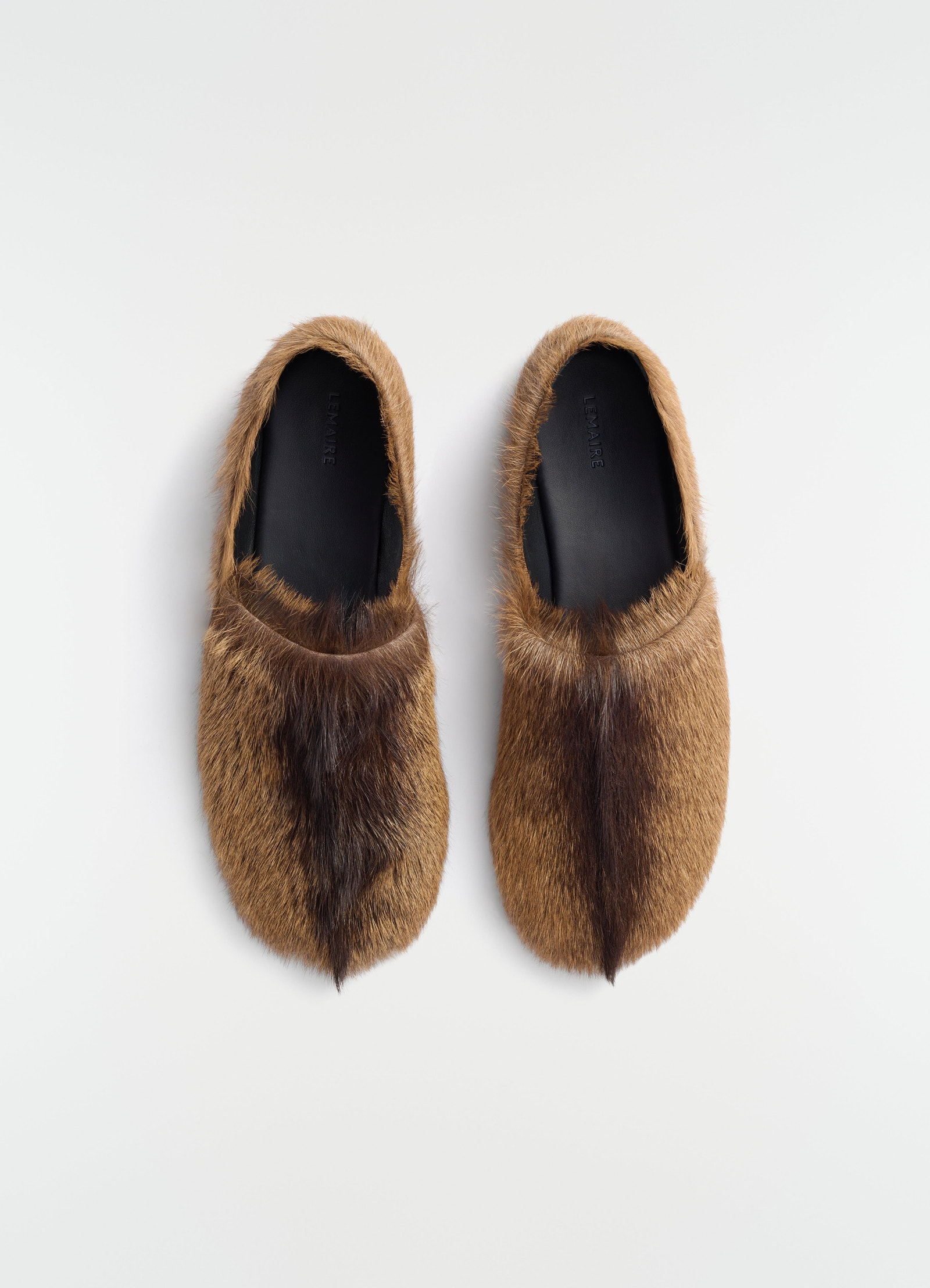 Mocassins en cuir de chèvre à poils longs, coloris marron, présenté à plat sur fond blanc