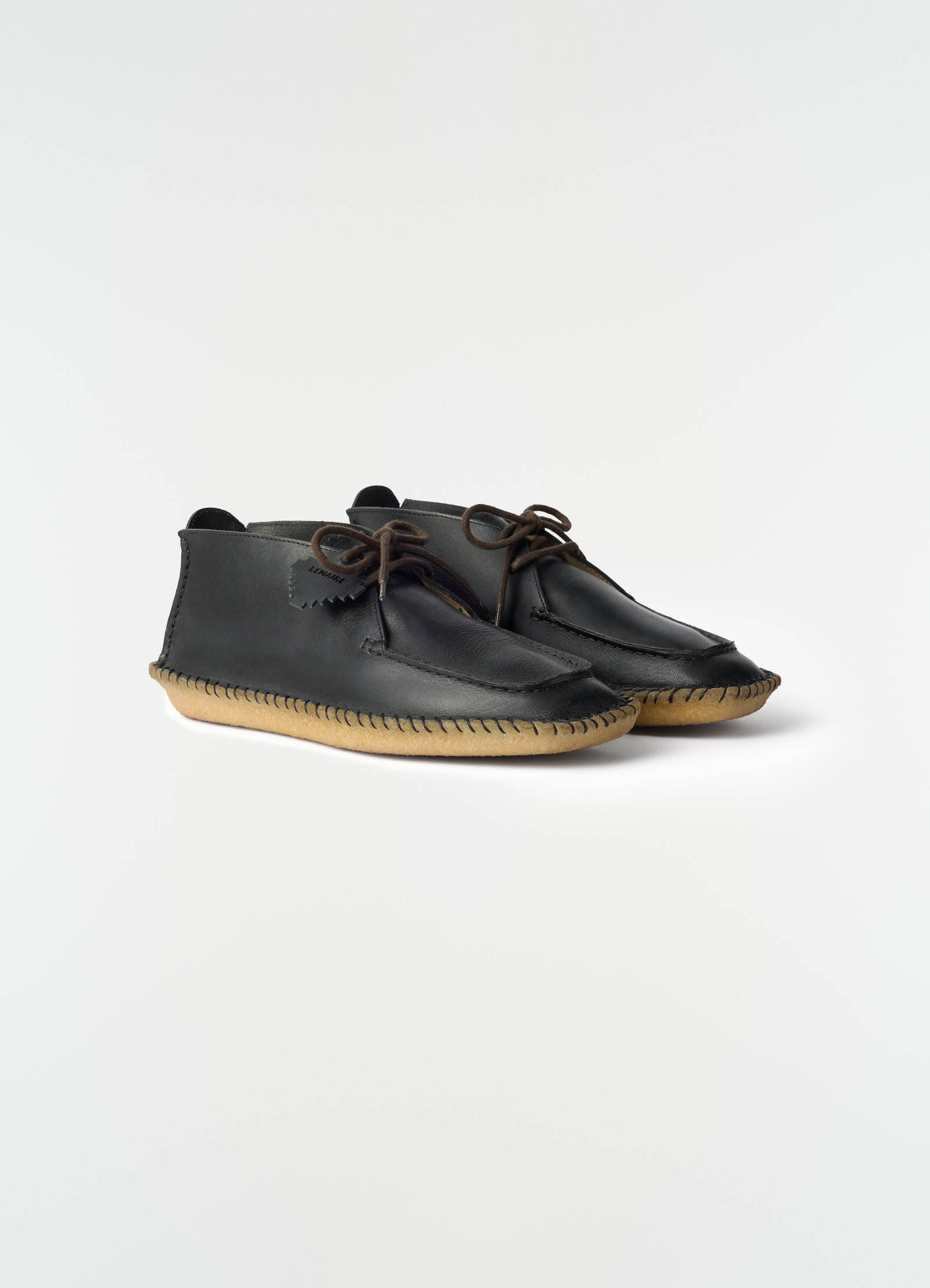 Desert moccasins black vegetable-tanned leather with gum sole lemaire side view on plain white background