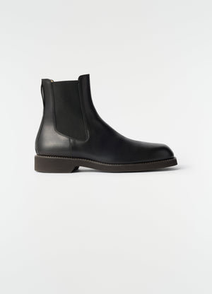 Chelsea ankle boots black shiny vegetable-tanned leather lemaire side view on plain white background