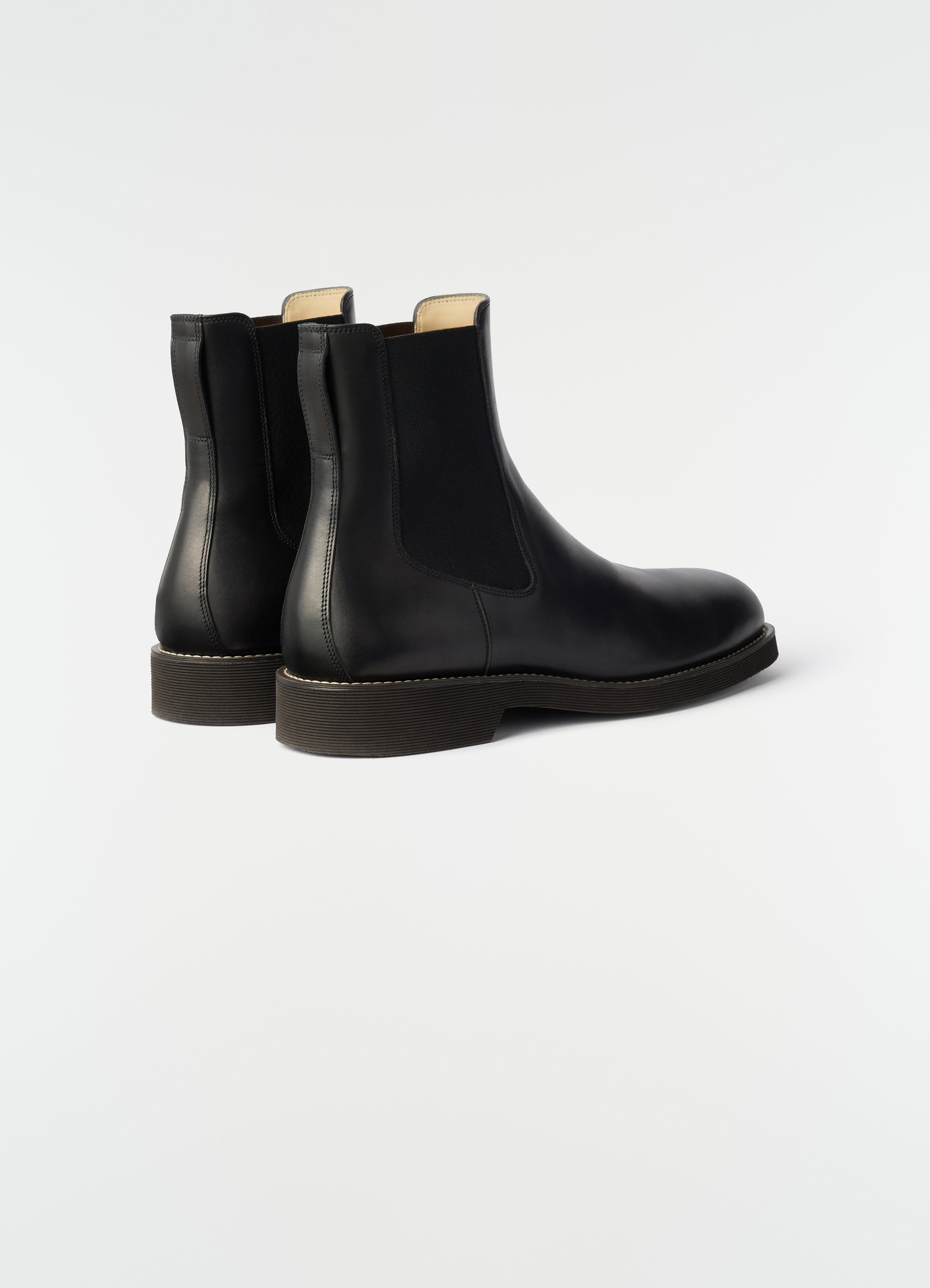 Chelsea ankle boots in black shiny vegetable-tanned leather with elastic side panels by lemaire back view on white background